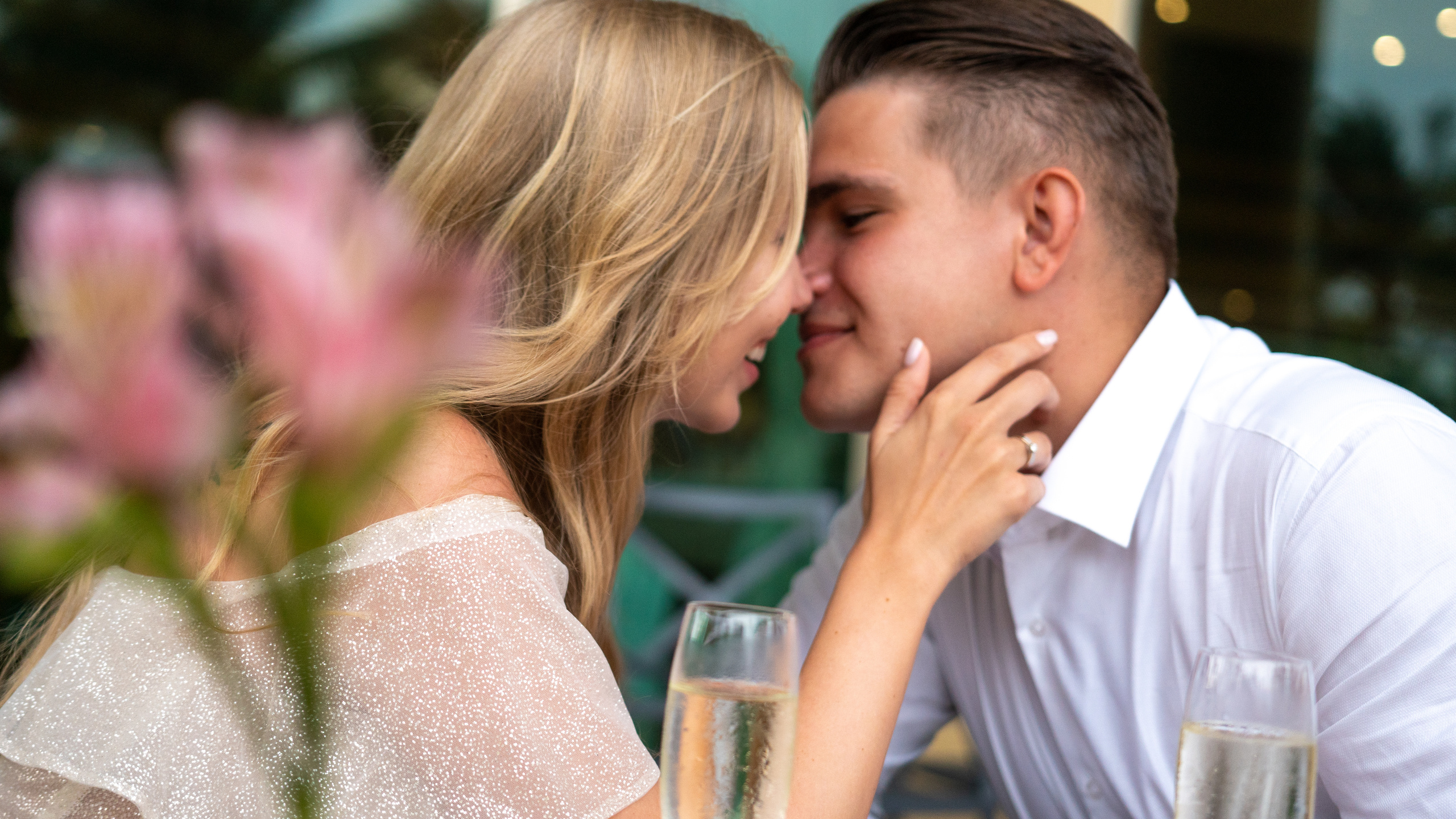 Engaged couple sharing a romantic moment with champagne at an outdoor dinner in Mexico