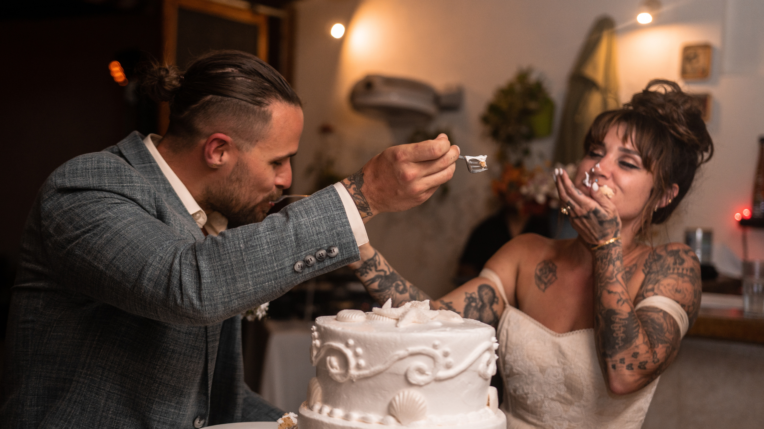 Beachfront cake cutting moment with candid emotion photography in Isla Mujeres