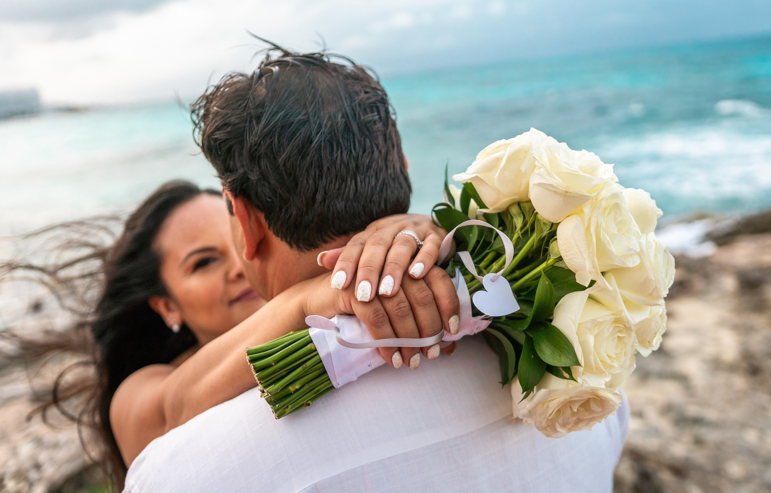 Elopement-style wedding photo in front of iconic lighthouse in Isla Mujeres – ocean view photography for couples in Mexico
