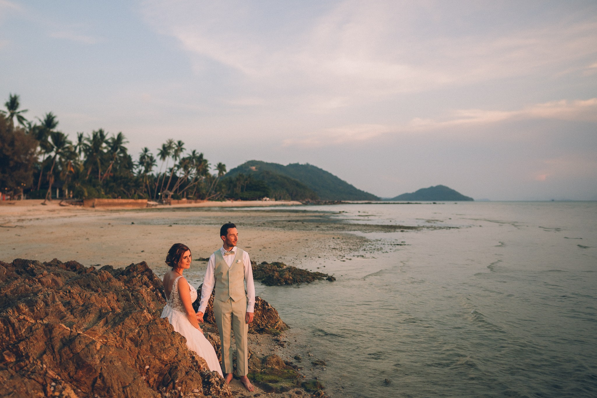 Wedding celebration with guests on a tropical sunset beach in Koh Samui
