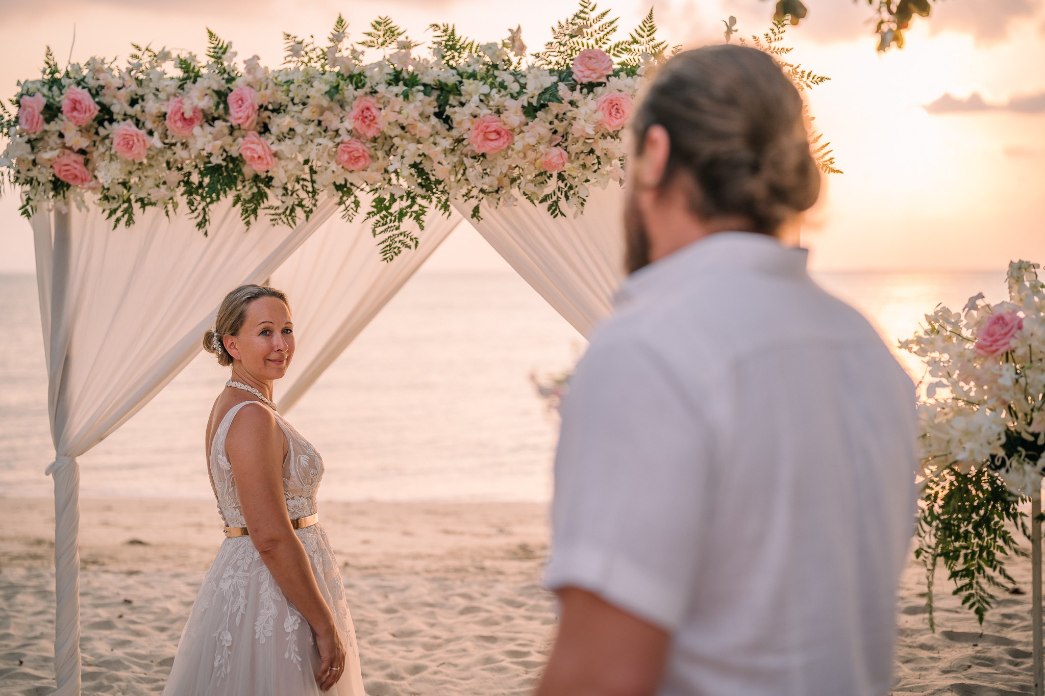 Destination beach wedding in Koh Samui, Thailand with the couple, family members and friends enjoying a tropical wedding ceremony by the sea