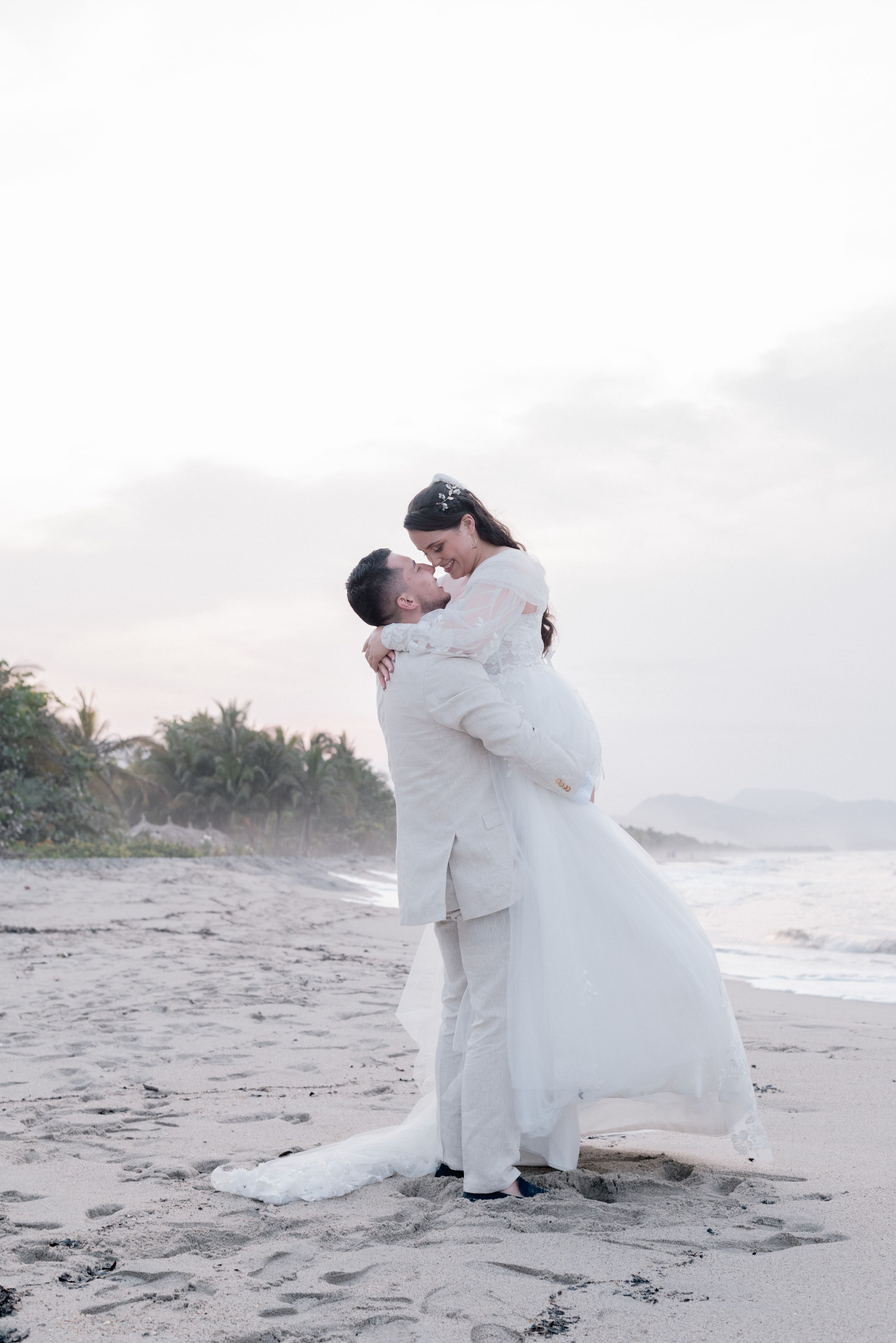 Novio corriendo en arena de playa Mareygua, momento de alegría en boda tropical Santa Marta