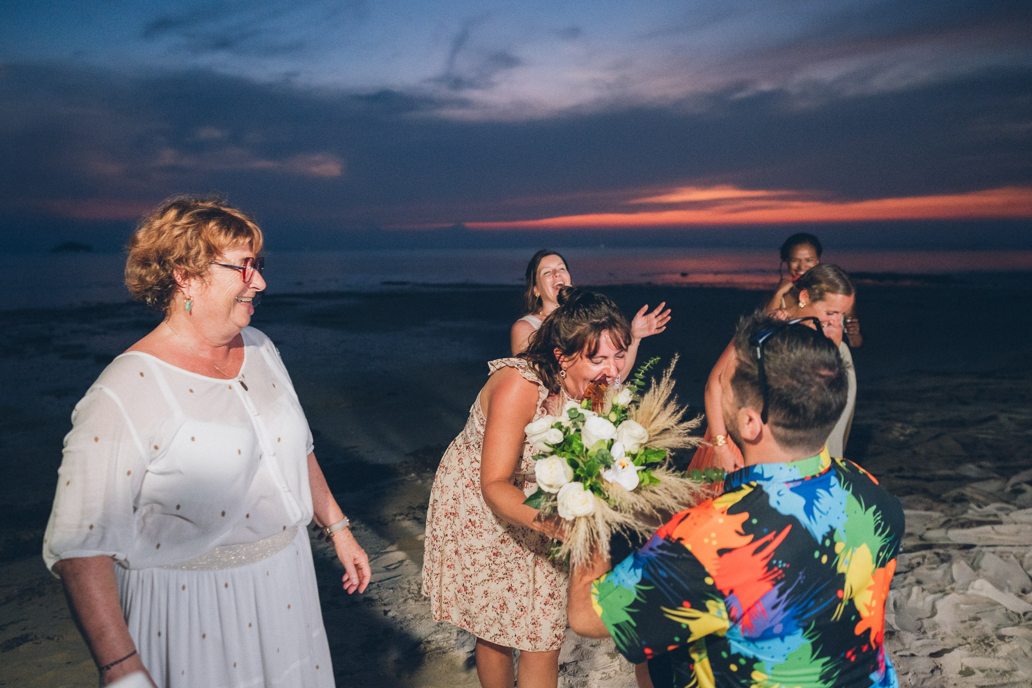 Wedding celebration with guests on a tropical sunset beach in Koh Samui