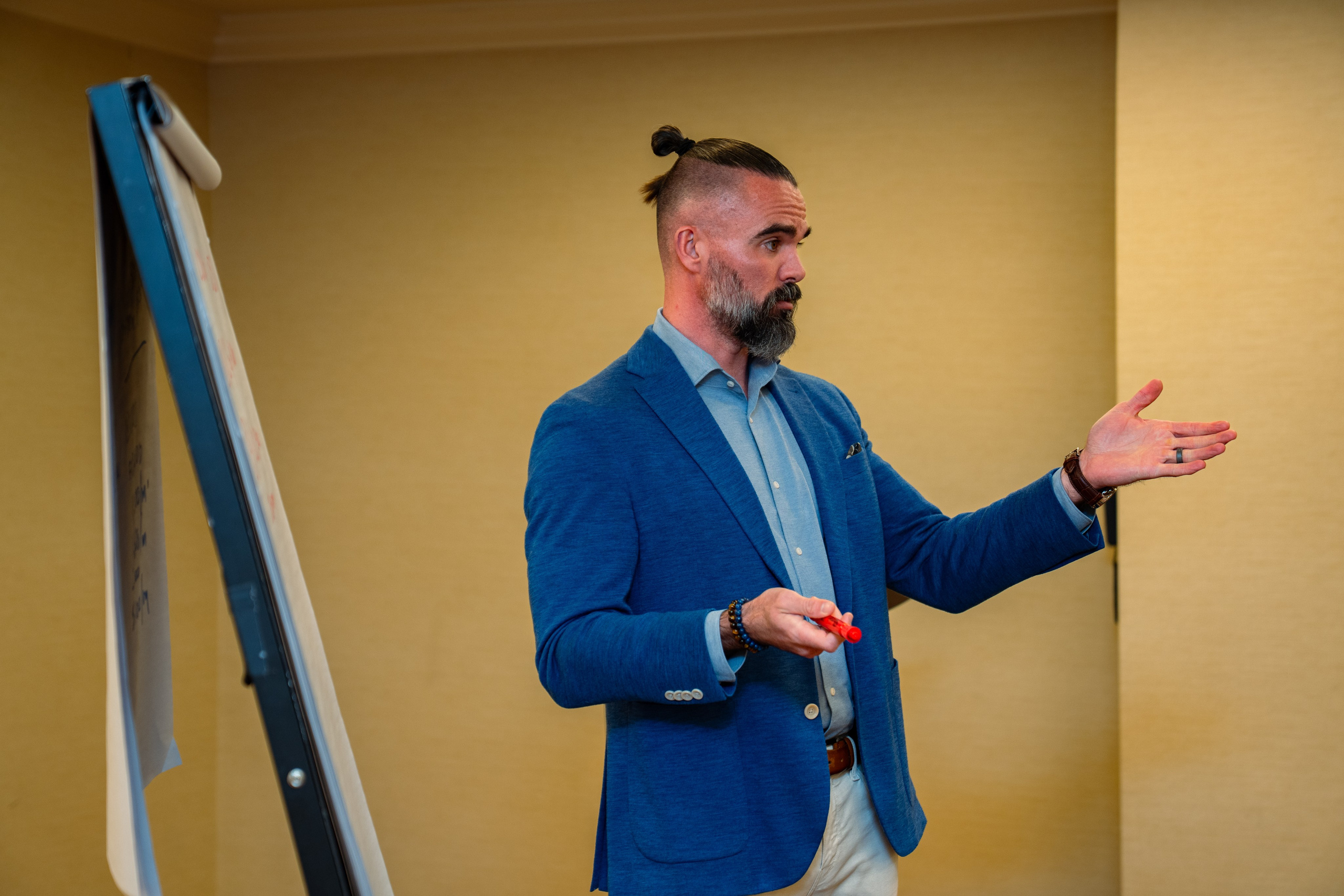 Matt Poechman gesturing while presenting to seated audience