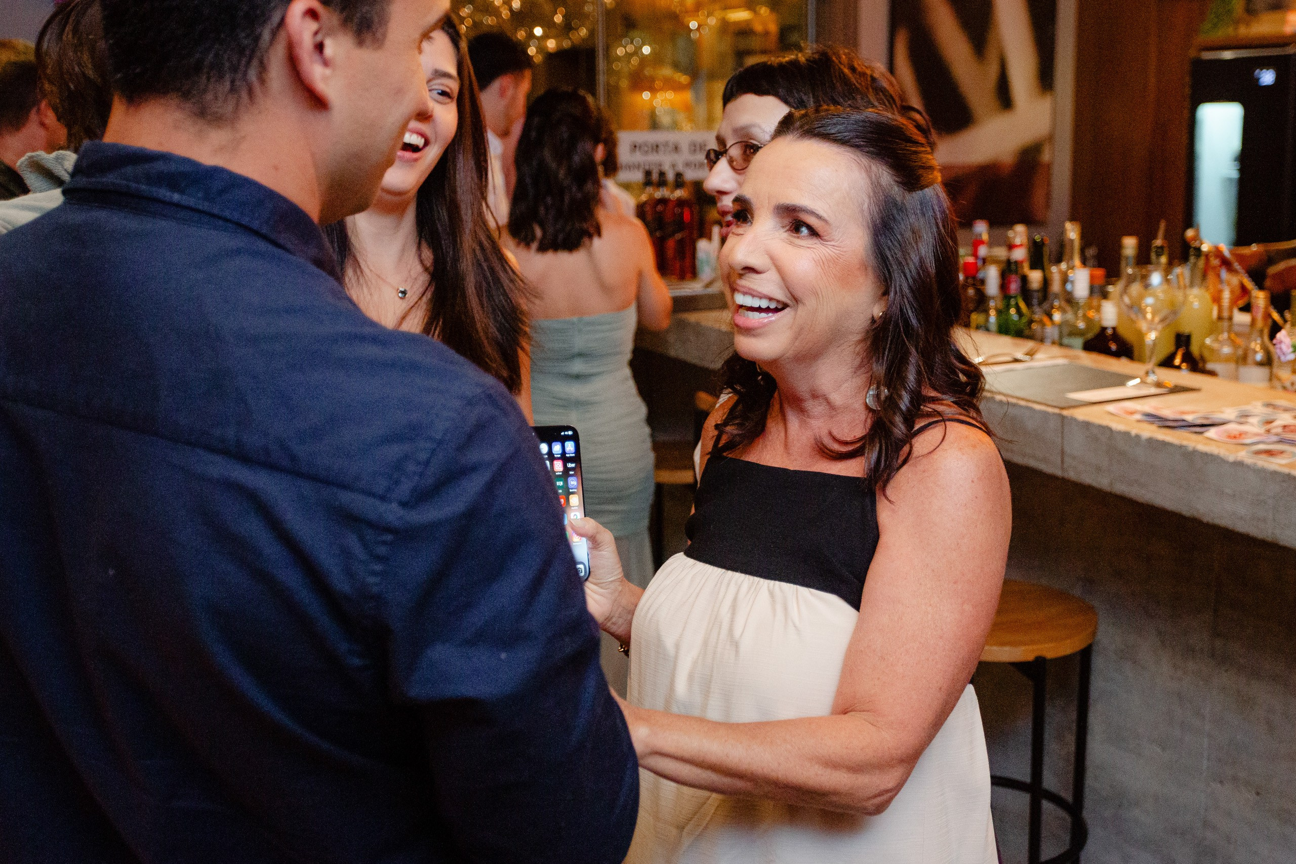 Fotógrafo de festa de formatura em Balneário Camboriú; convidados sorridentes conversando perto do bar durante a recepção.