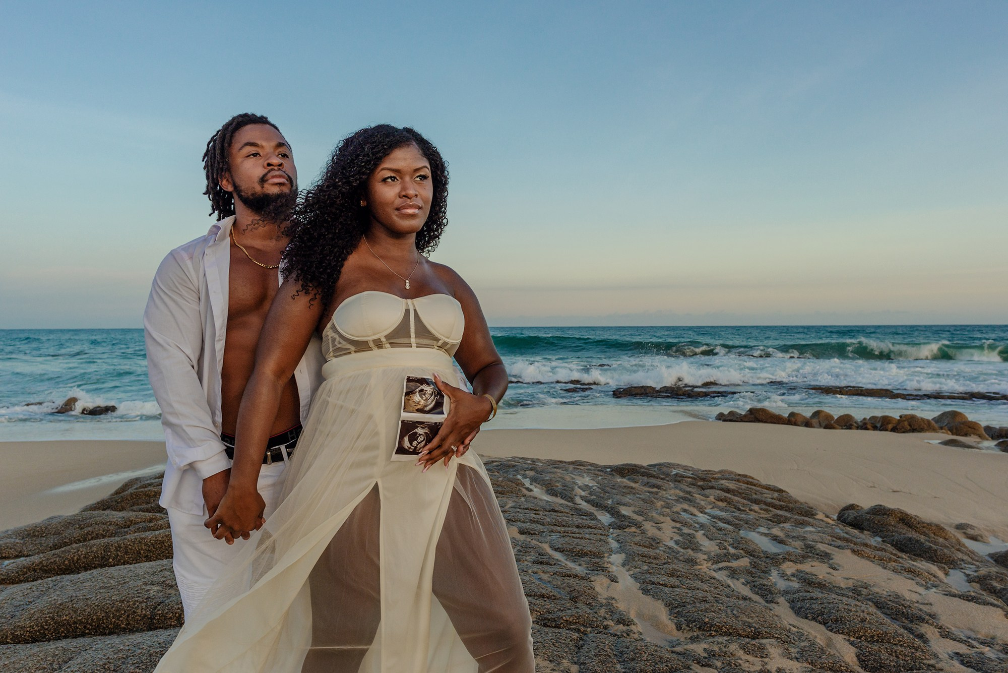 Maternity portrait in Cabo – pregnant woman surrounded by ocean and palm trees, symbolizing the magic of motherhood and the love of awaiting new life