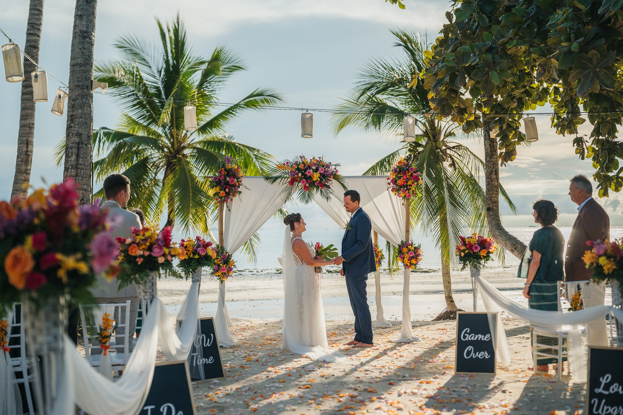 Destination beach wedding in Koh Samui, Thailand with the couple, family members and friends enjoying a tropical wedding ceremony by the sea