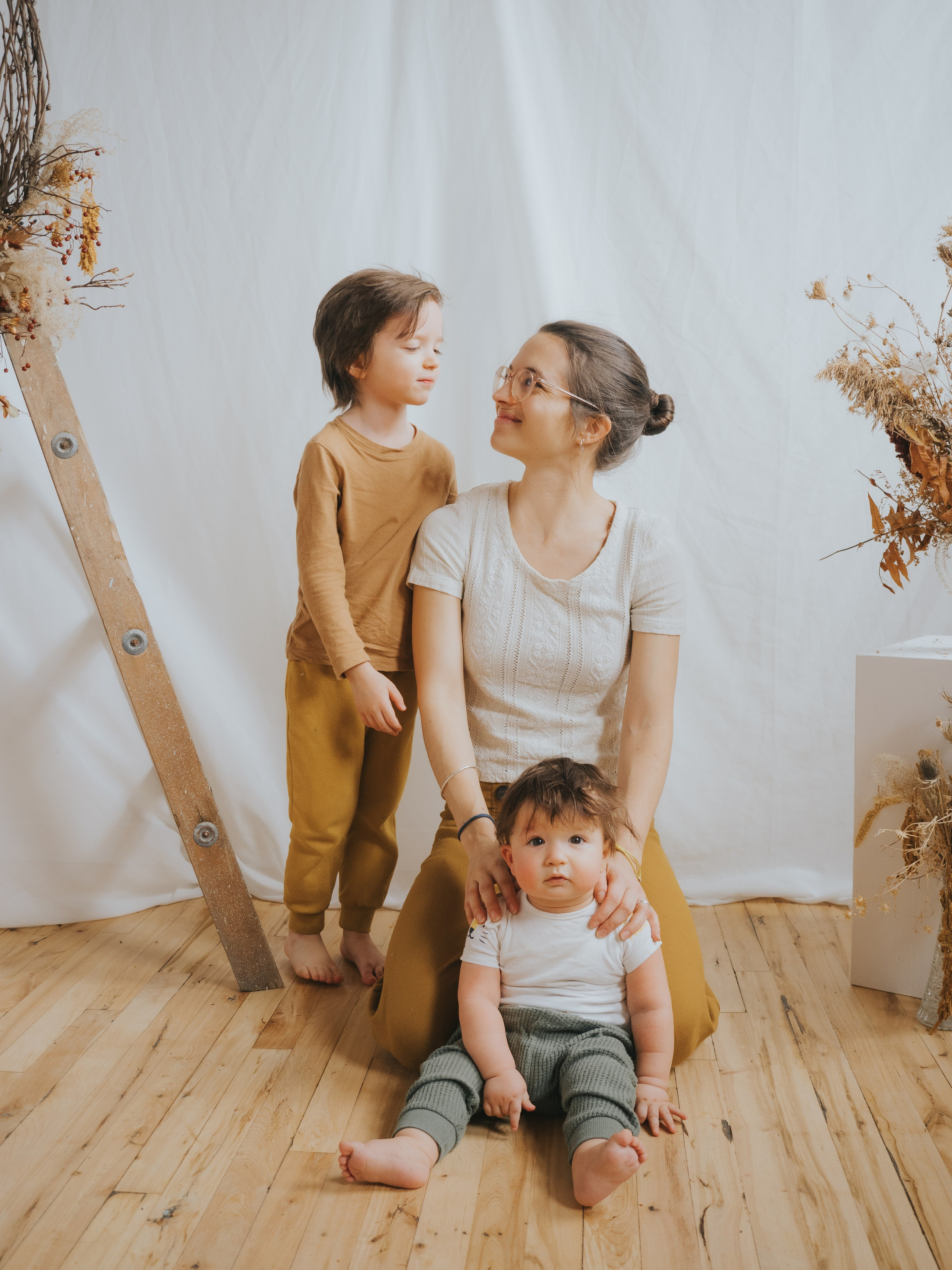 Mère avec deux enfants regardant le frère aîné.