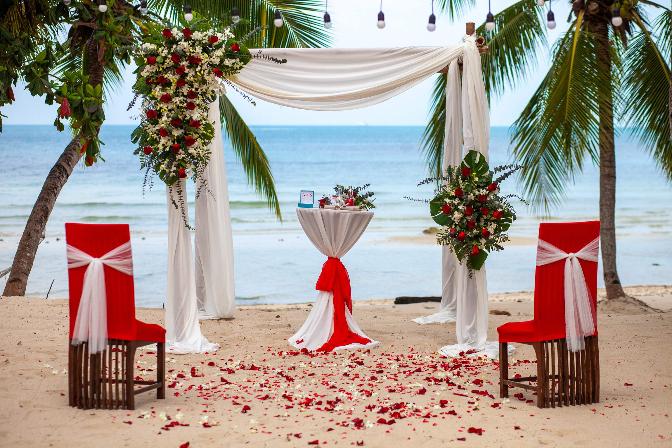 Elegant beach wedding setup on Koh Samui, Thailand with bride, groom, flowers and stunning sea backdrop
