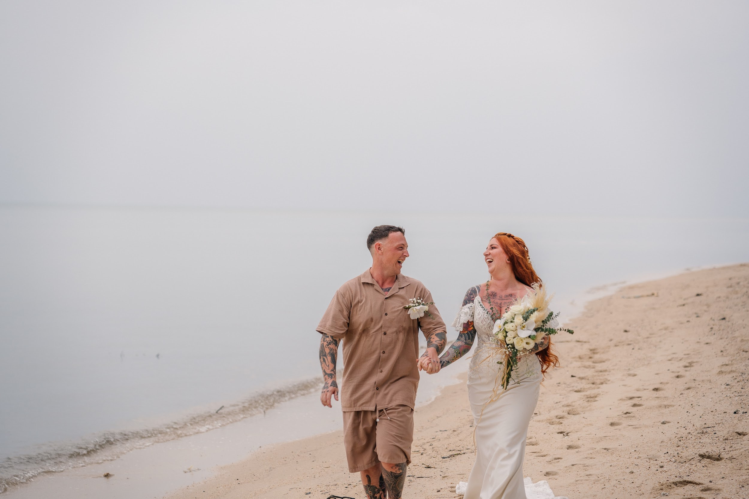 Elegant beach wedding setup on Koh Samui, Thailand with bride, groom, flowers and stunning sea backdrop