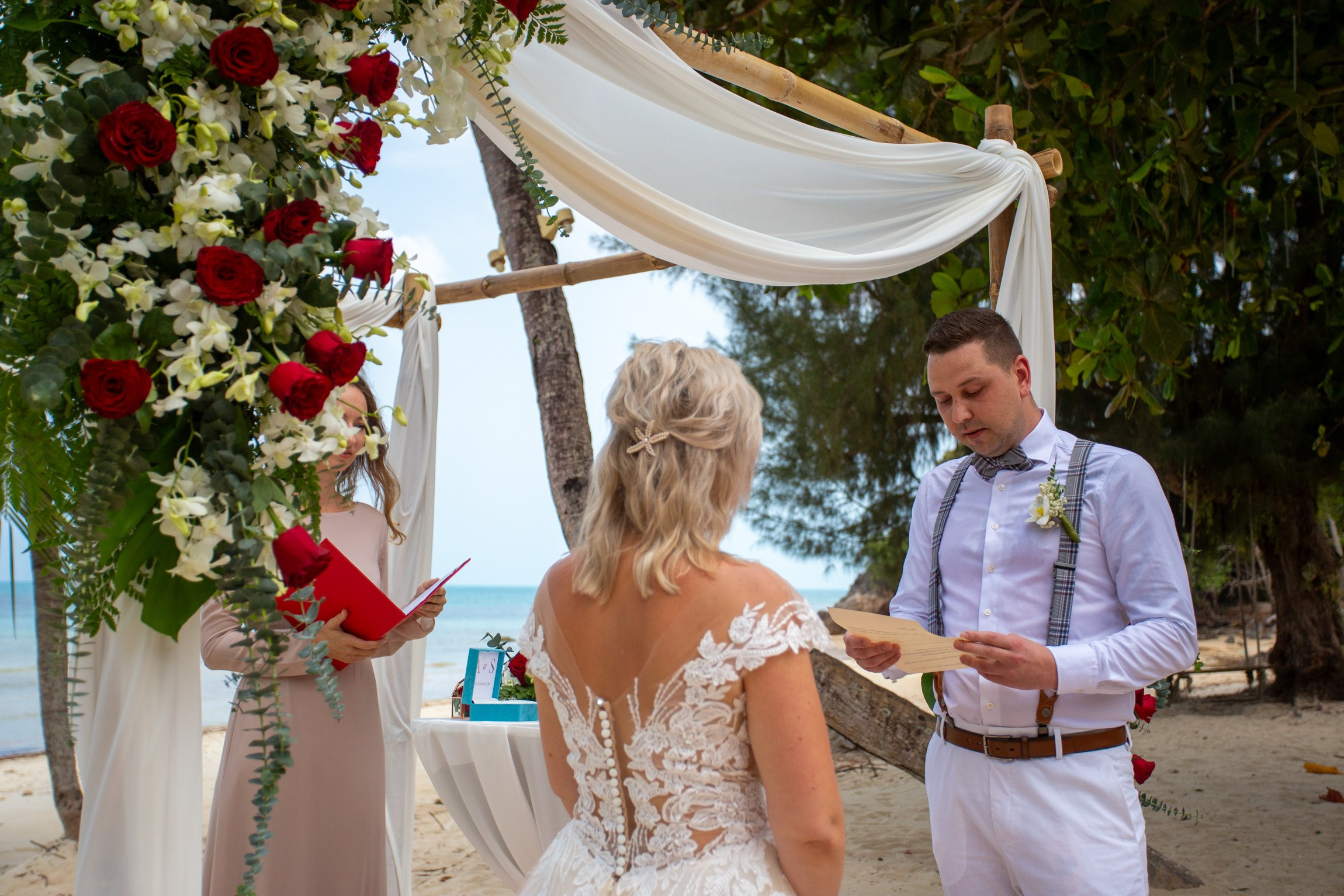 Elegant beach wedding setup on Koh Samui, Thailand with bride, groom, flowers and stunning sea backdrop