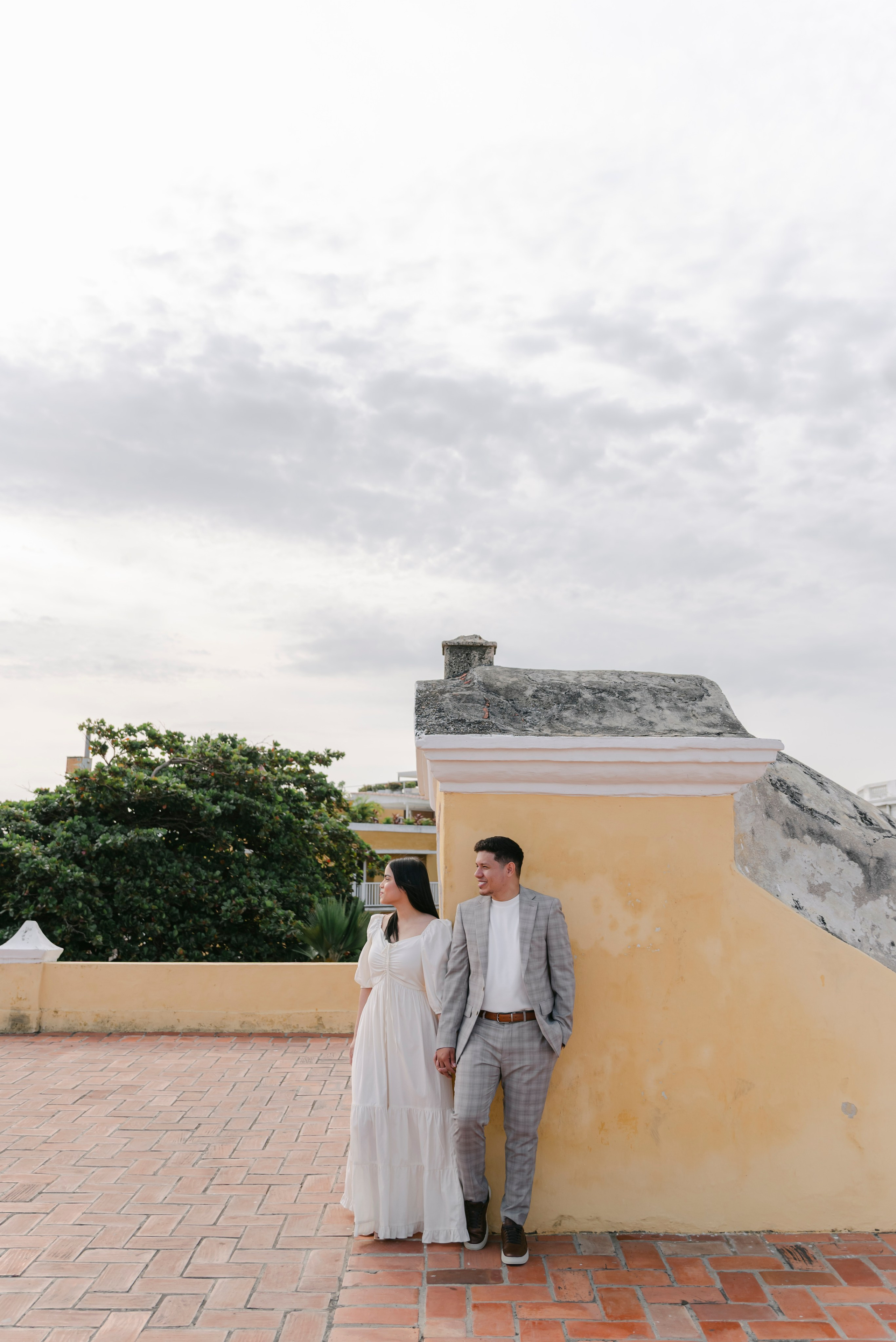 Novios en ubicación elevada al atardecer, fotografía cinematográfica romántica