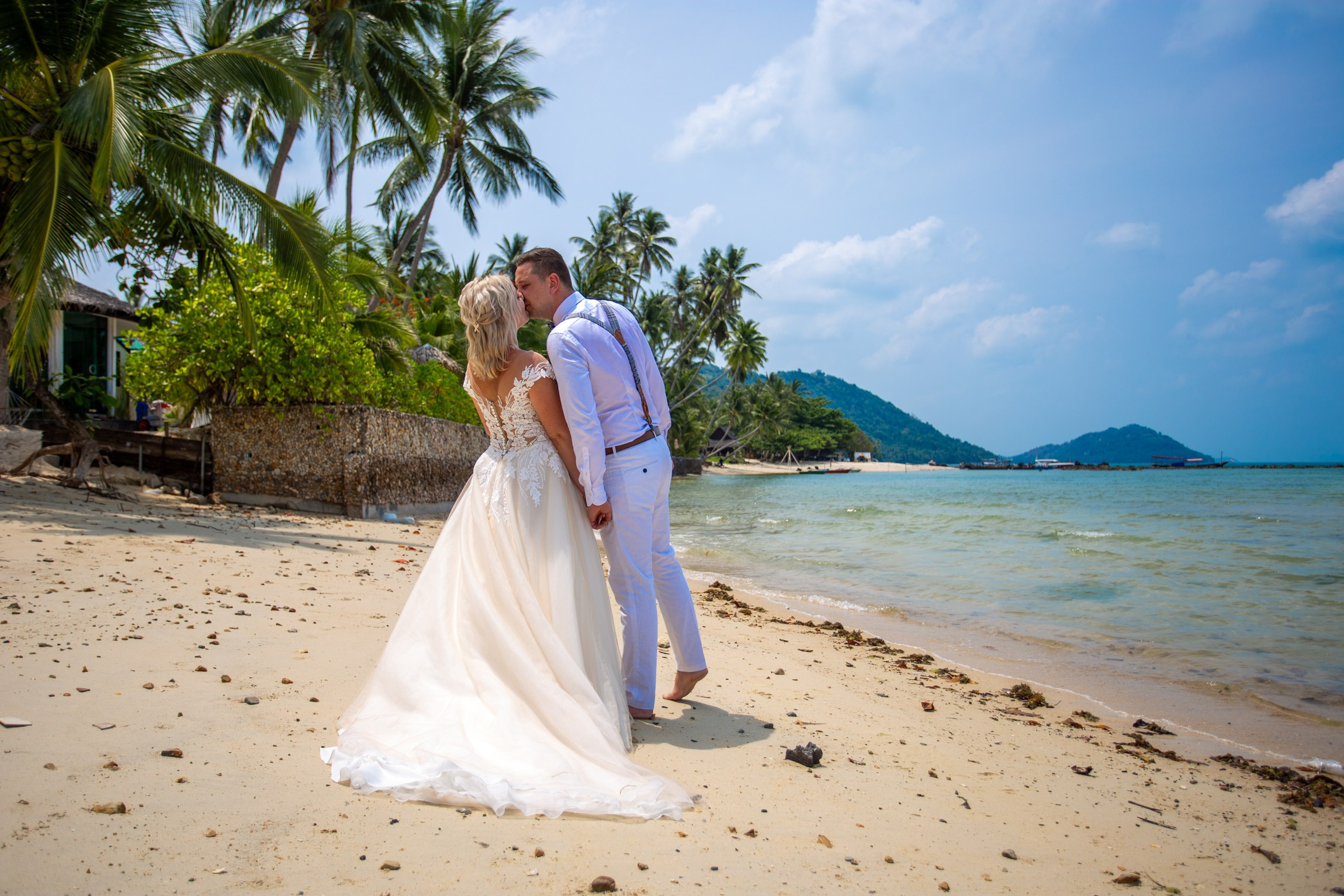 Bride and groom during a romantic beach wedding ceremony on Koh Samui, Thailand, surrounded by tropical scenery and ocean views