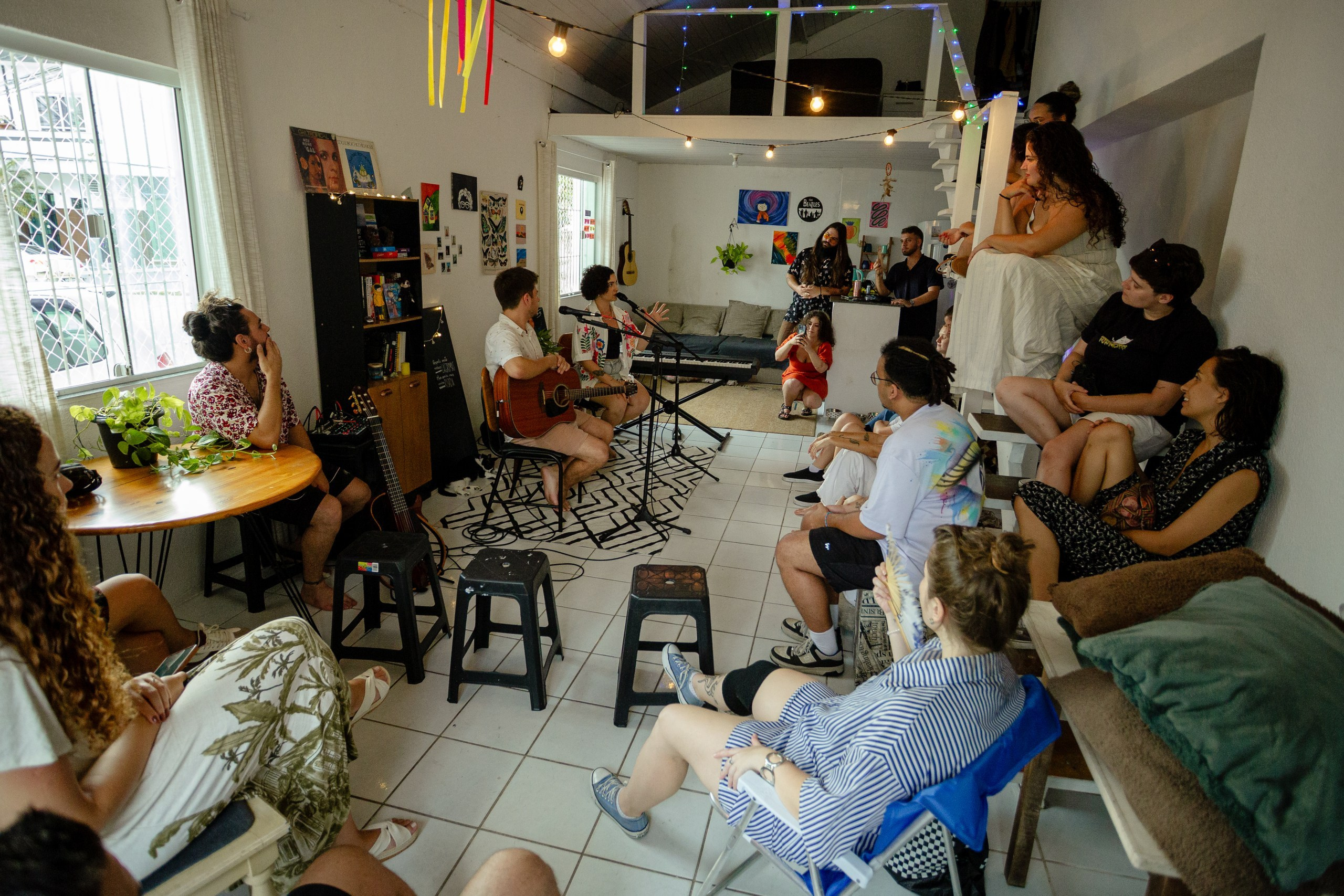 Cobertura fotográfica de apresentação musical ao vivo reunindo público em ambiente cultural intimista, Itajaí.