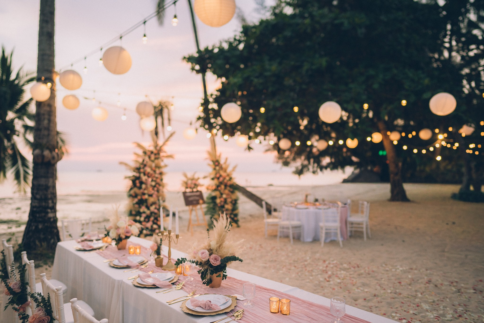 Wedding celebration with guests on a tropical sunset beach in Koh Samui