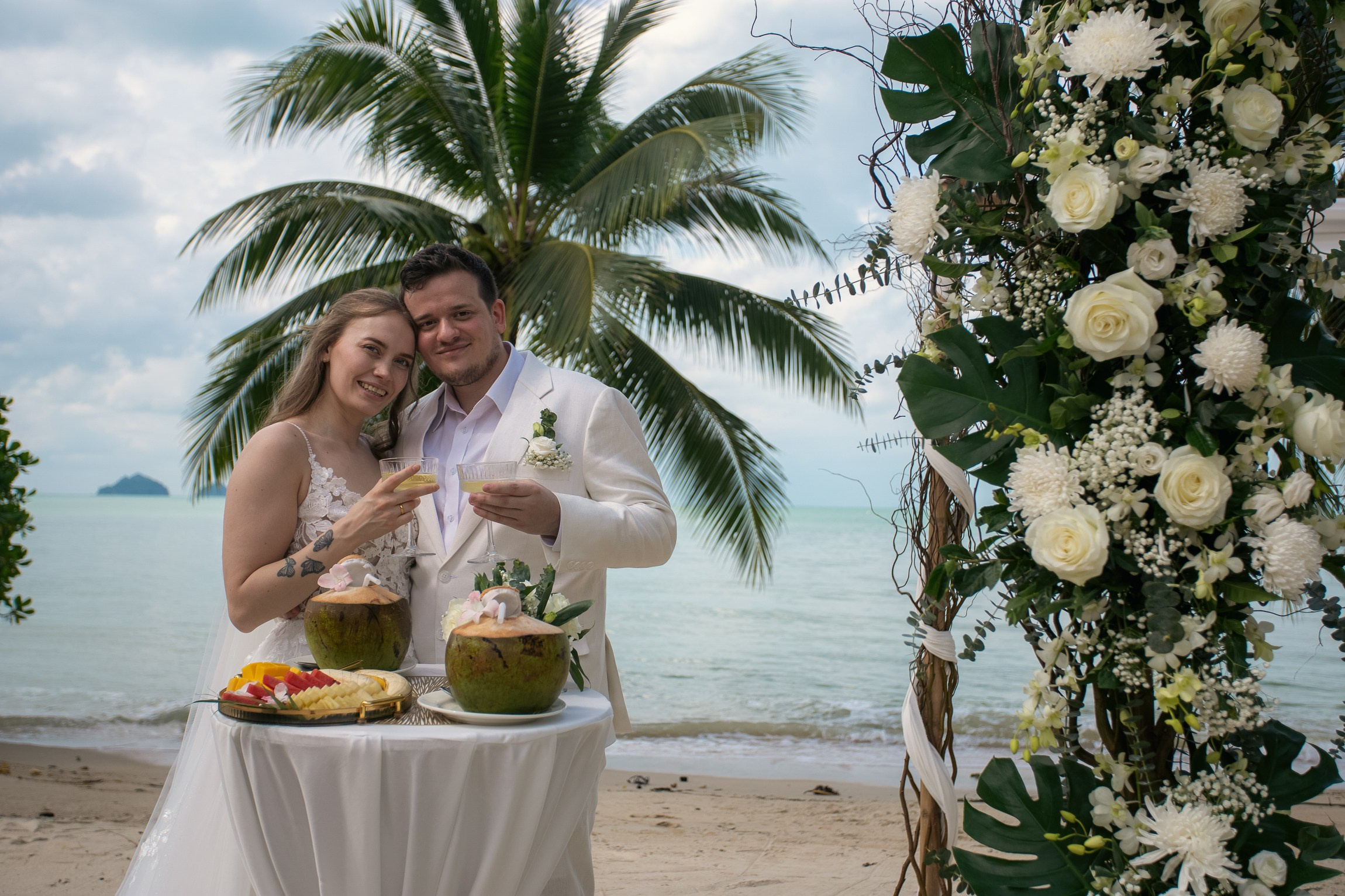 Romantic destination wedding on Koh Samui beach with tropical flowers, ocean views and happy newlyweds