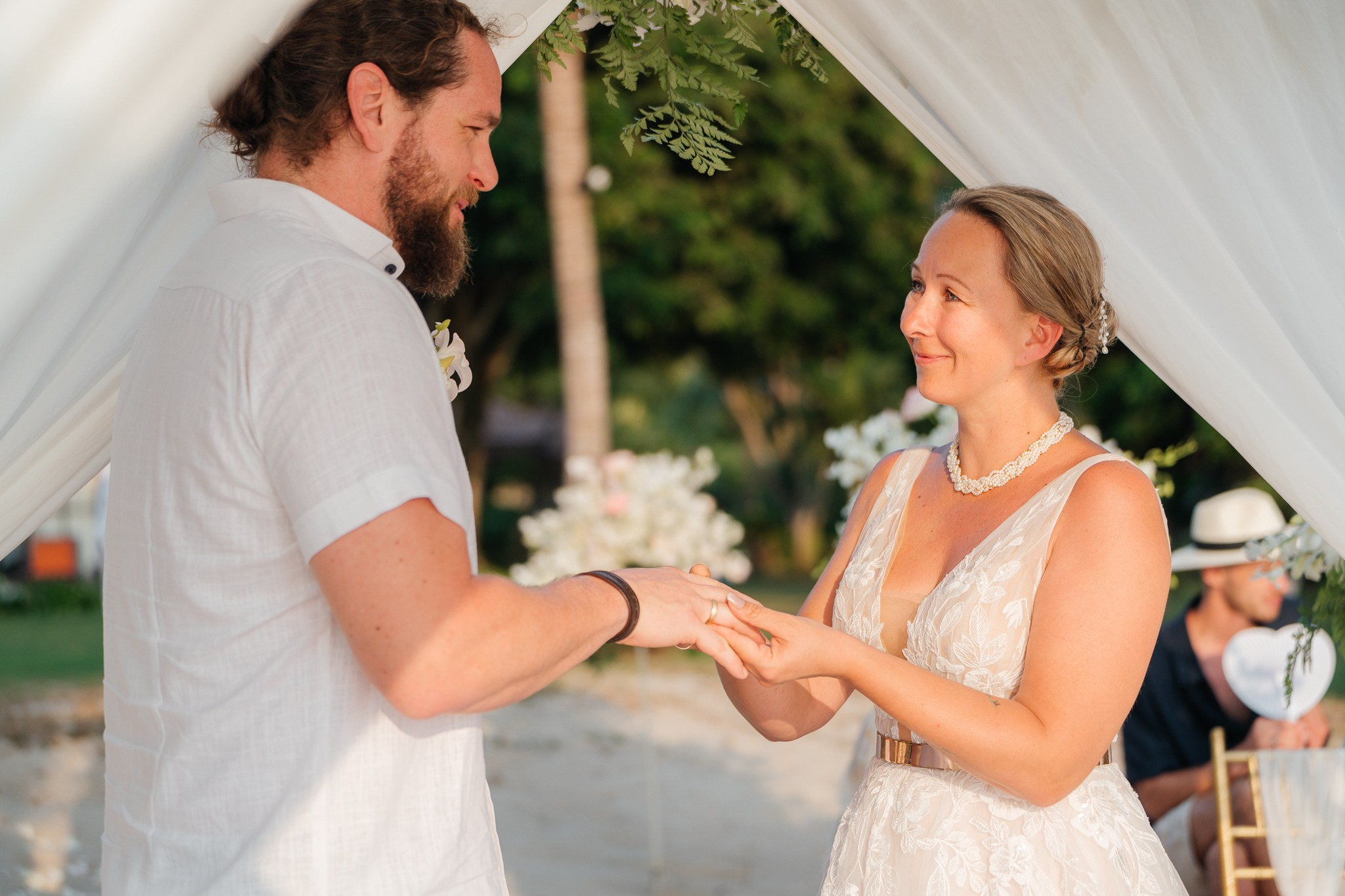 Bride and groom celebrating a beautiful beach wedding in Koh Samui, Thailand, surrounded by friends and family with tropical ocean views