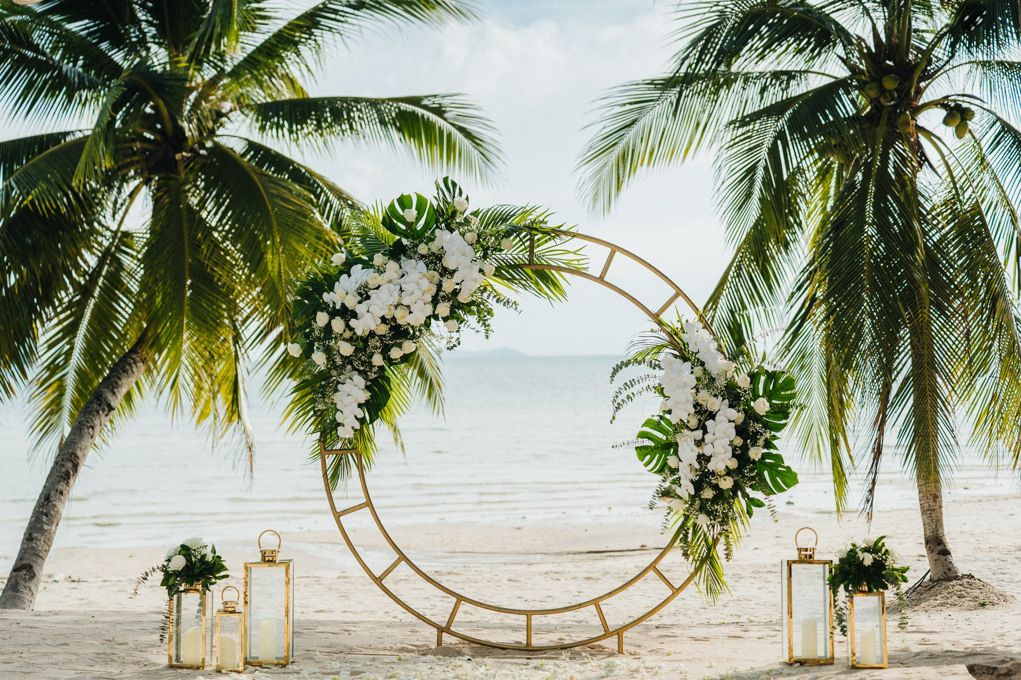 Bride and groom celebrating a beach wedding with their children in Koh Samui, Thailand, surrounded by tropical scenery and ocean views
