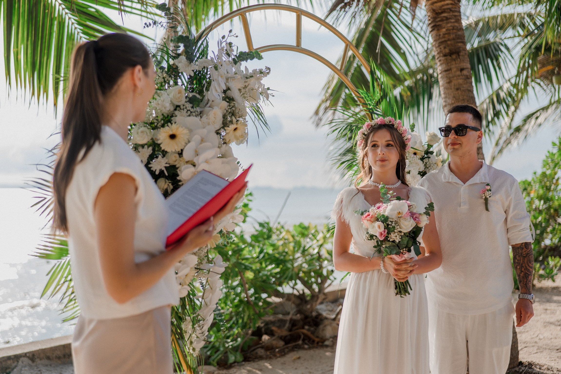 Bride and groom exchanging vows on a private sunset beach