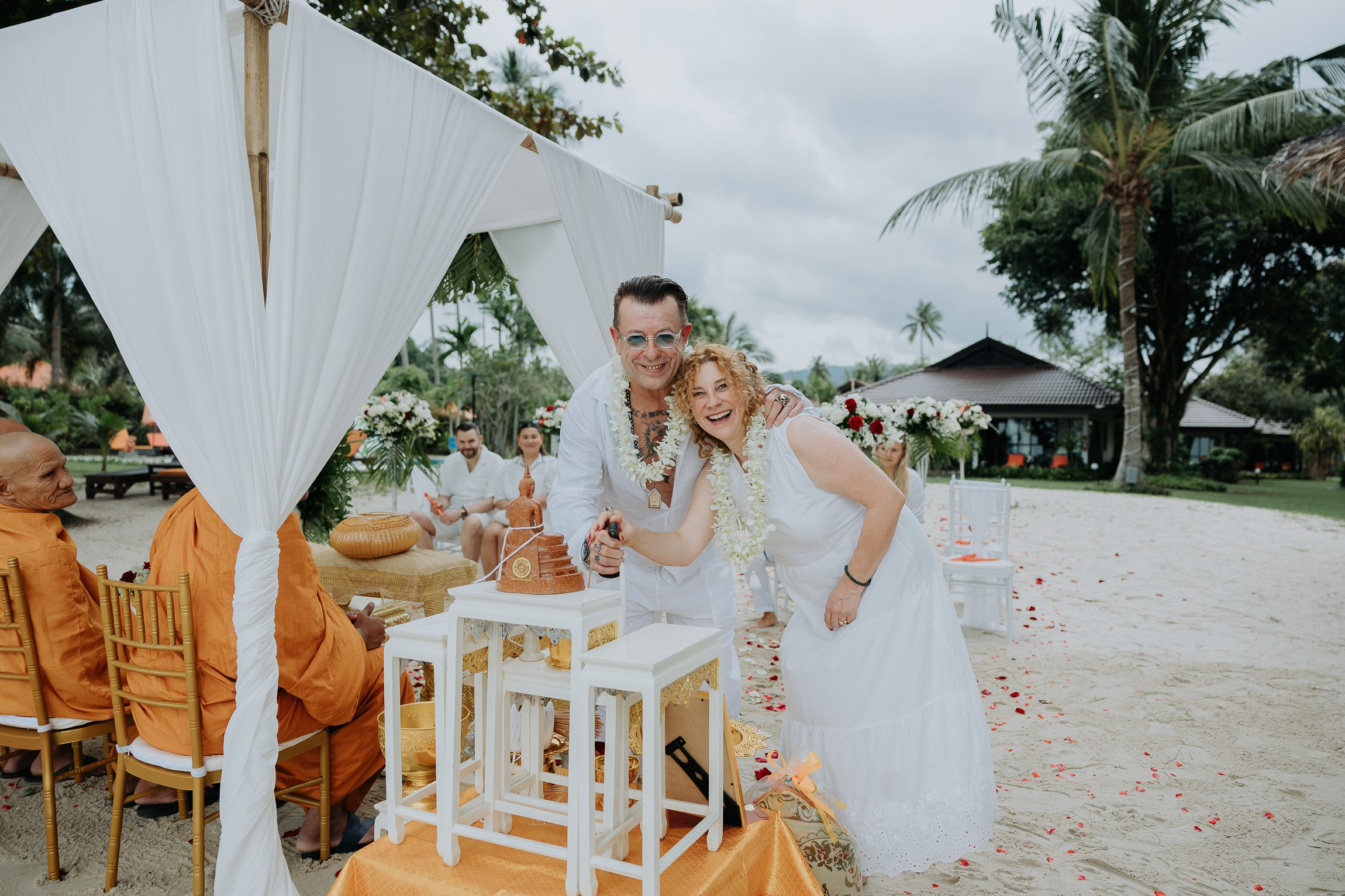 Couple with guests celebrating a spiritual Buddhist wedding ceremony on Koh Samui