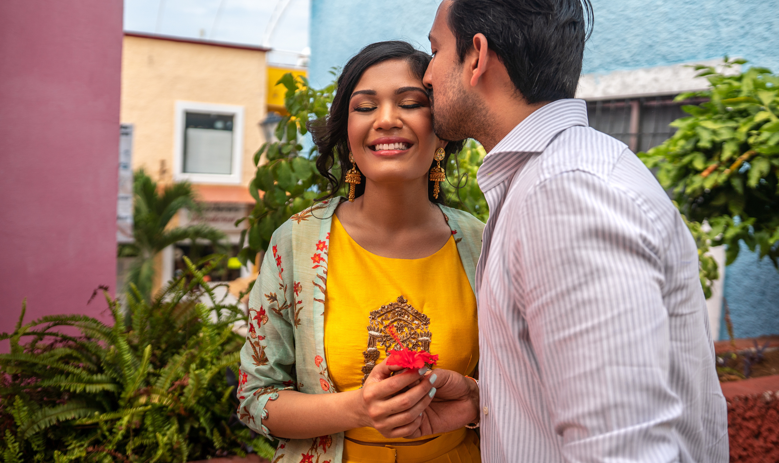 Natural light couple photo in a cozy Cancún courtyard with vibrant colors and artistic composition by a Mexico-based lifestyle photographer.