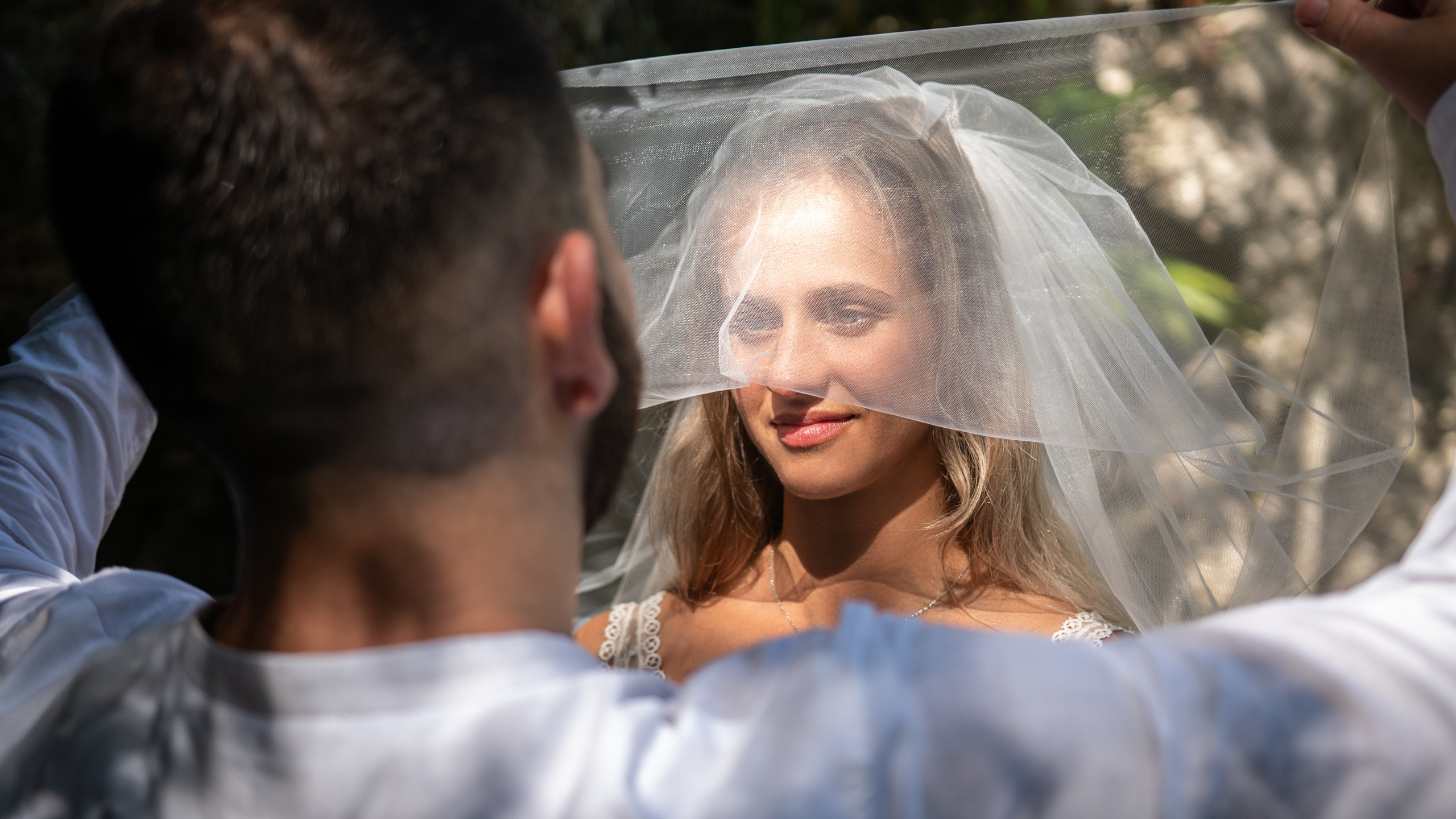 Groom holding bride during post-wedding shoot in cenote