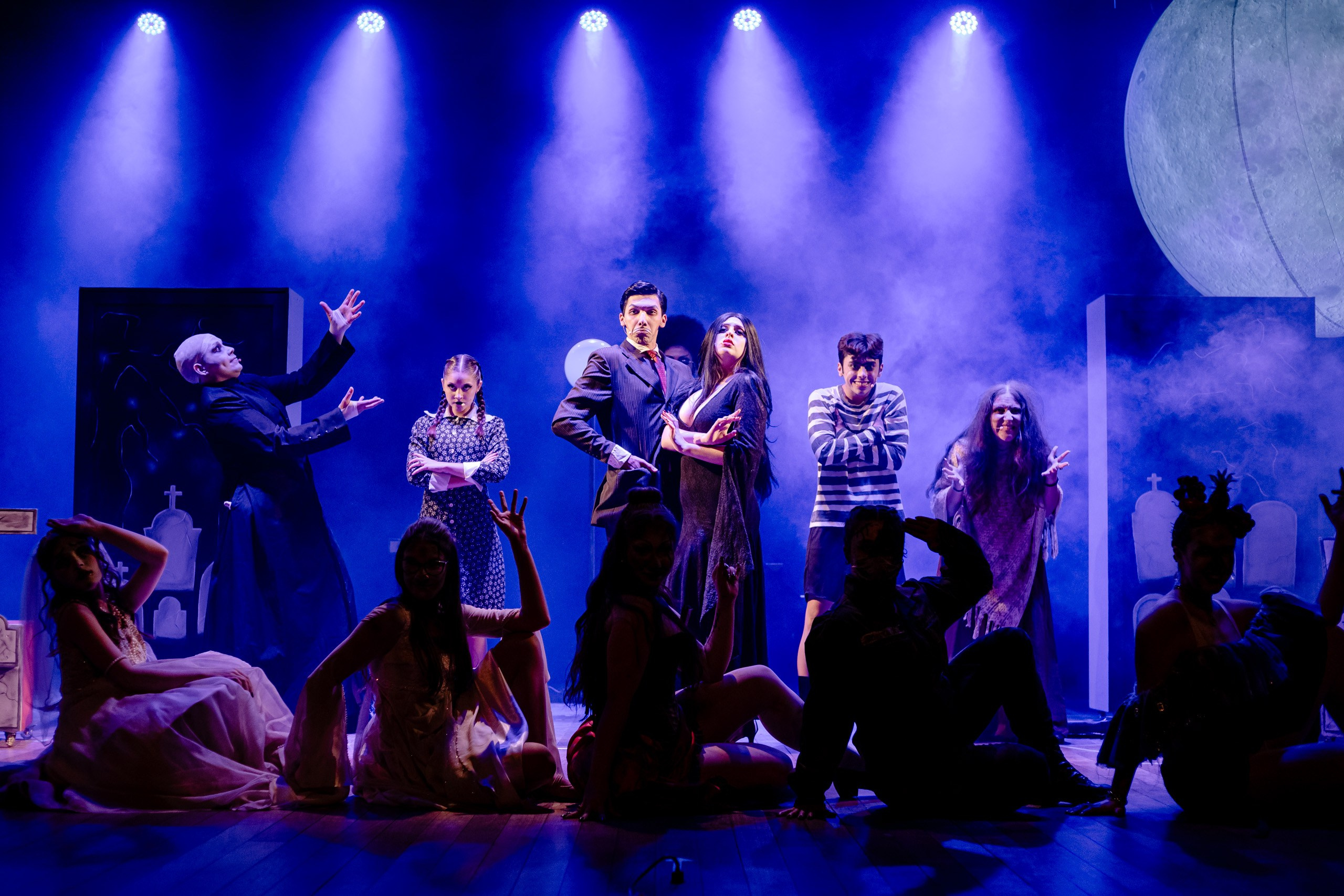 Apresentação teatral com grupo dançando no palco.