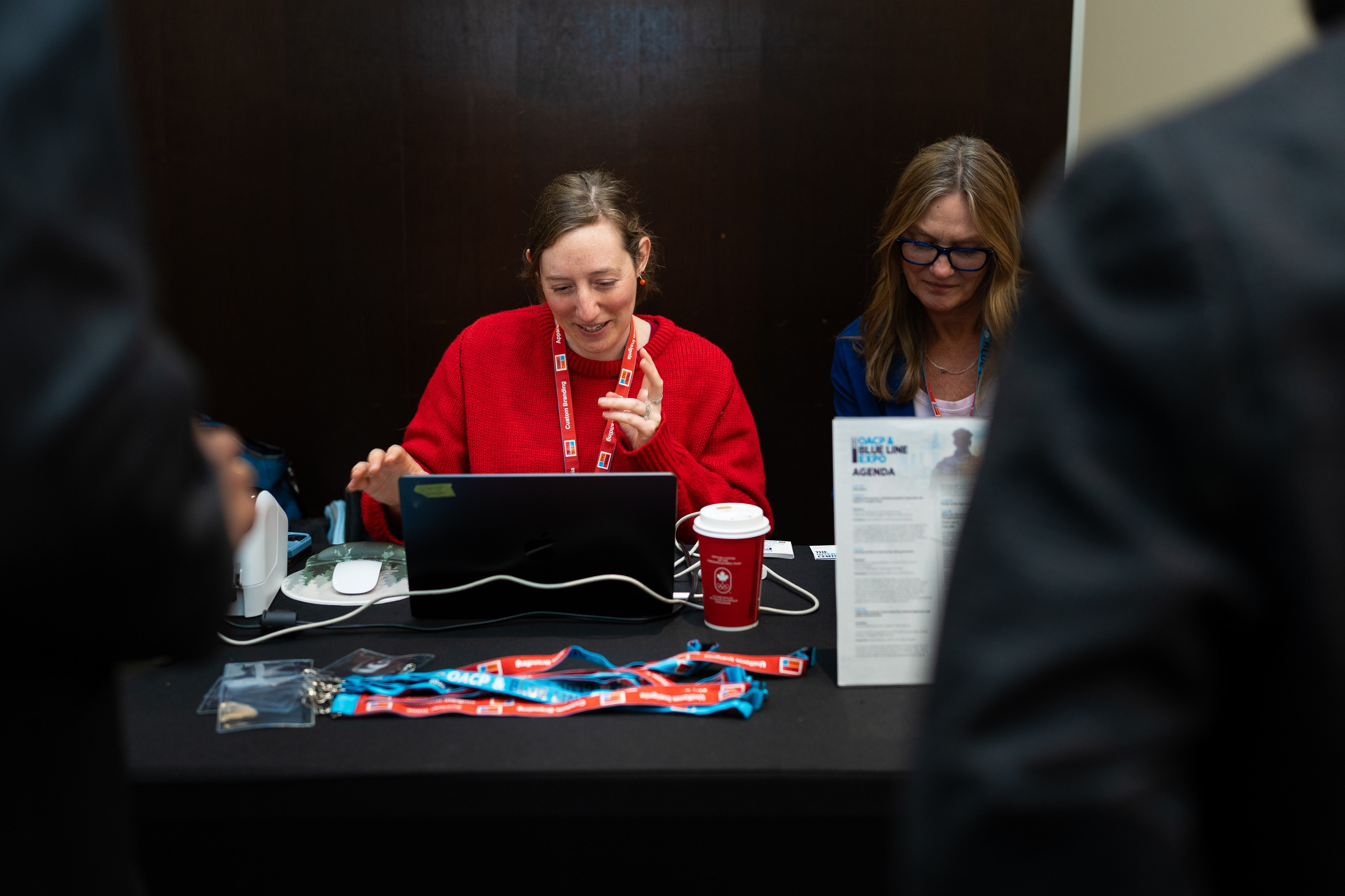 Exhibitor staff seated at registration table, Blueline Expo 2026 Toronto