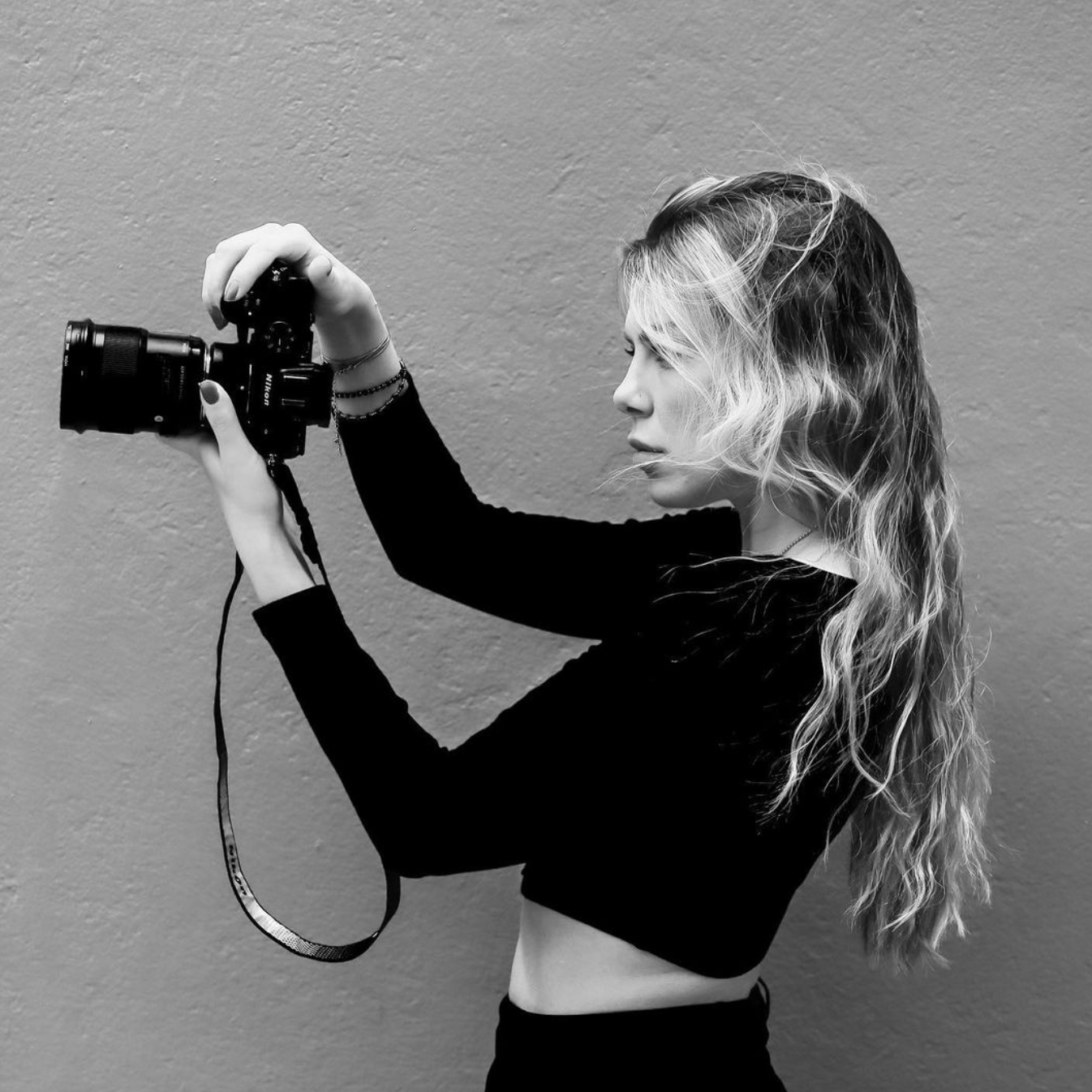 Retrato de Dasha, fotógrafa creativa, con su cámara en mano, lista para trabajar en eventos corporativos y sesiones fotográficas.
