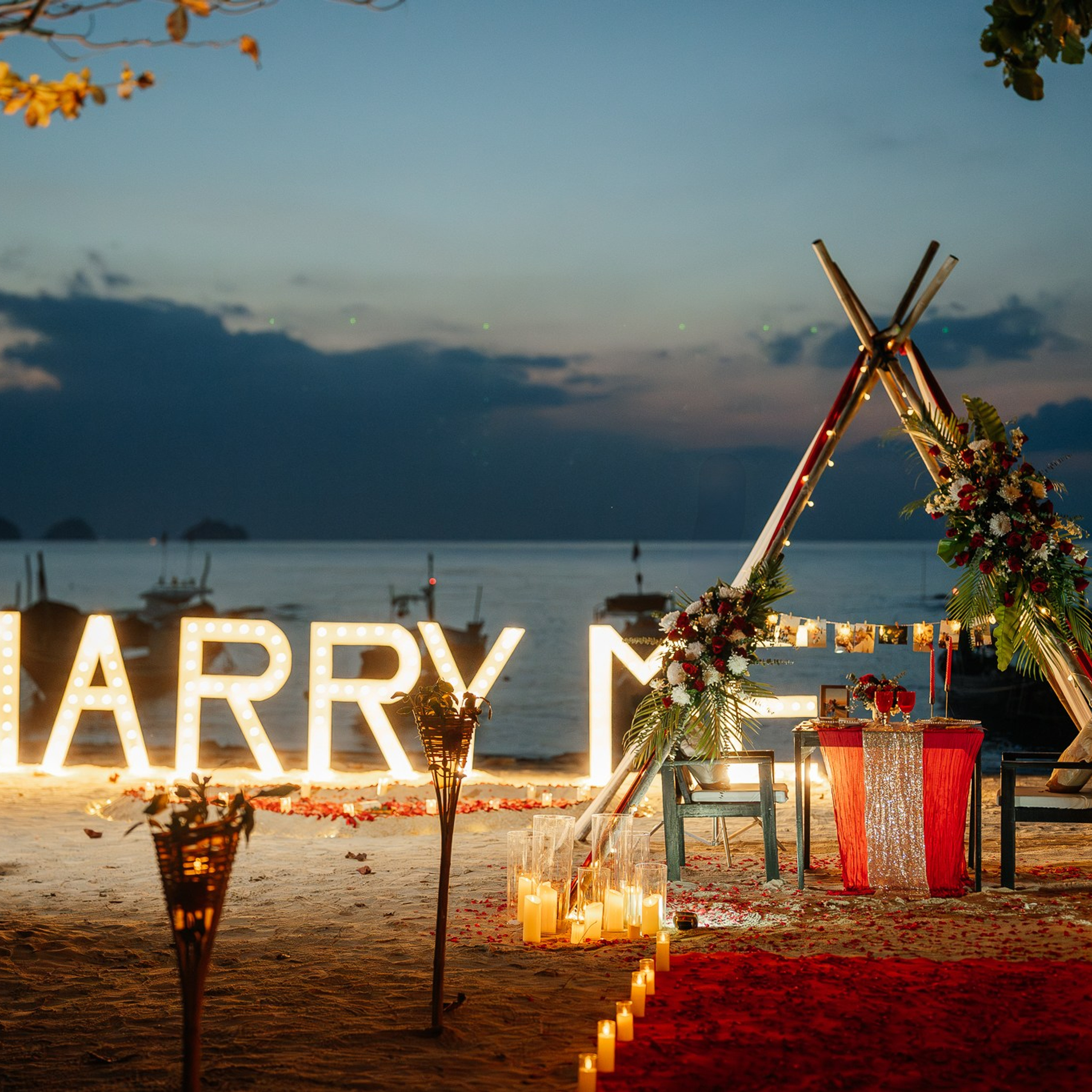 Romantic beach proposal setup in Koh Samui with candles and flower arch.