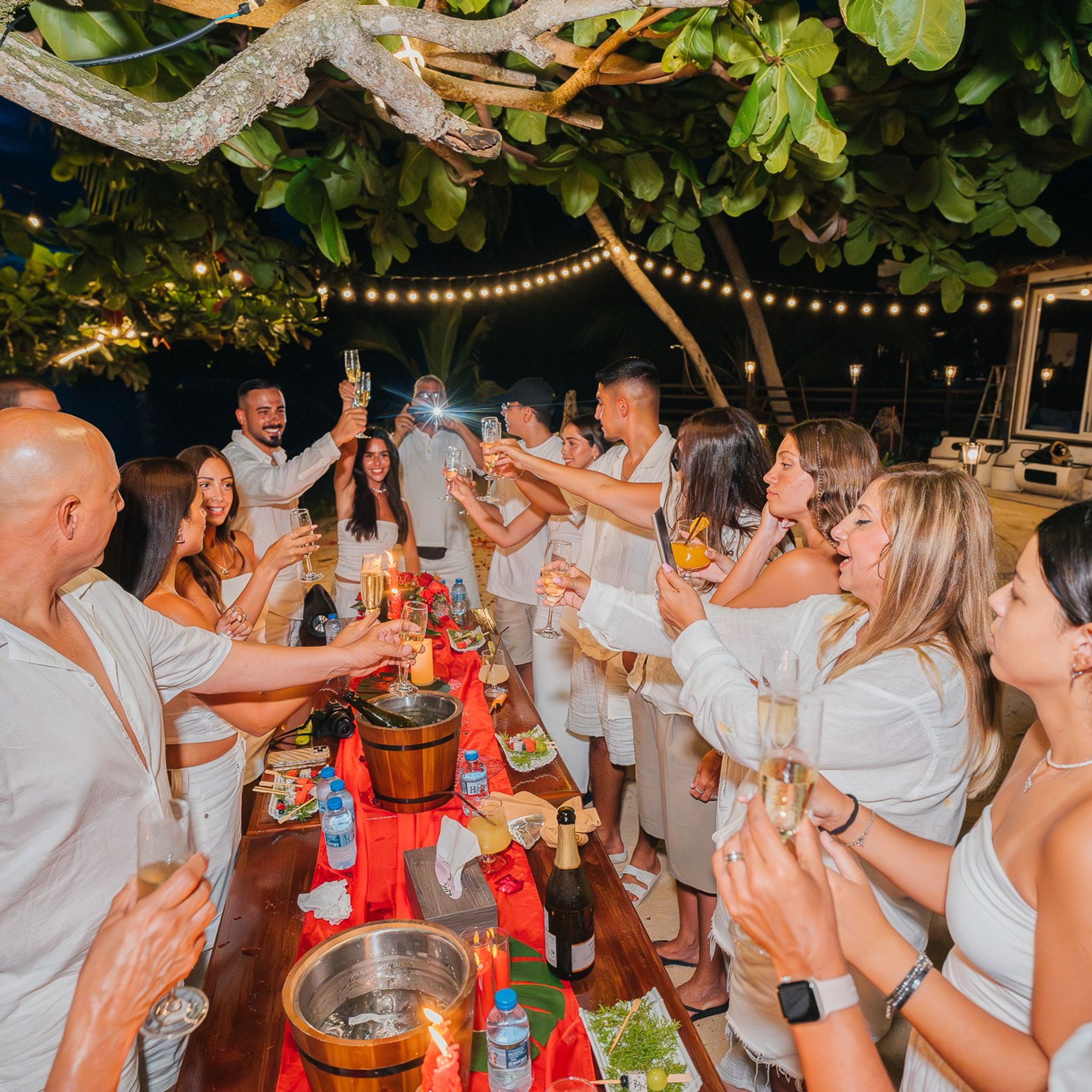 Romantic beach proposal setup in Koh Samui with candles and flower arch.