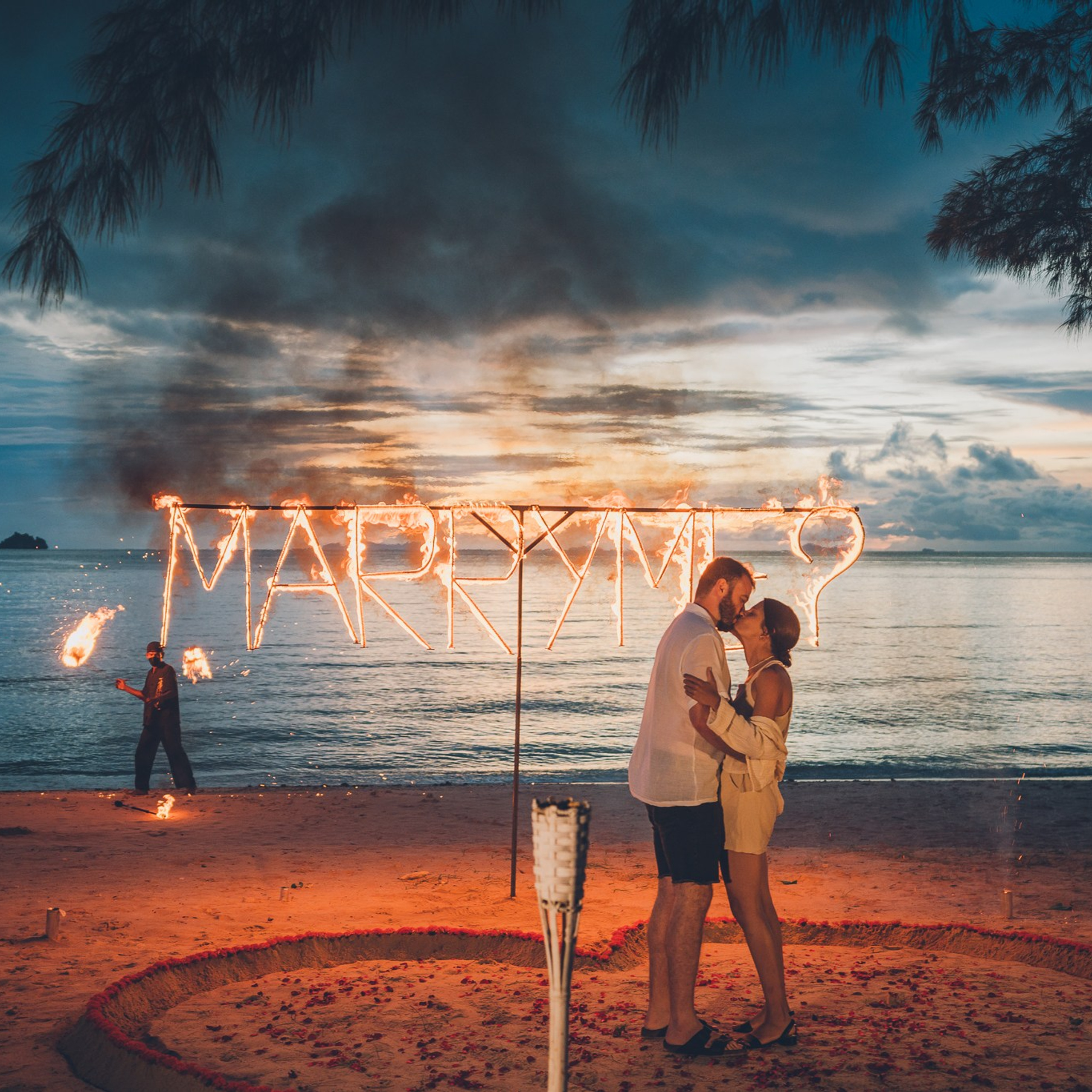 Romantic beach proposal setup in Koh Samui with candles and flower arch.