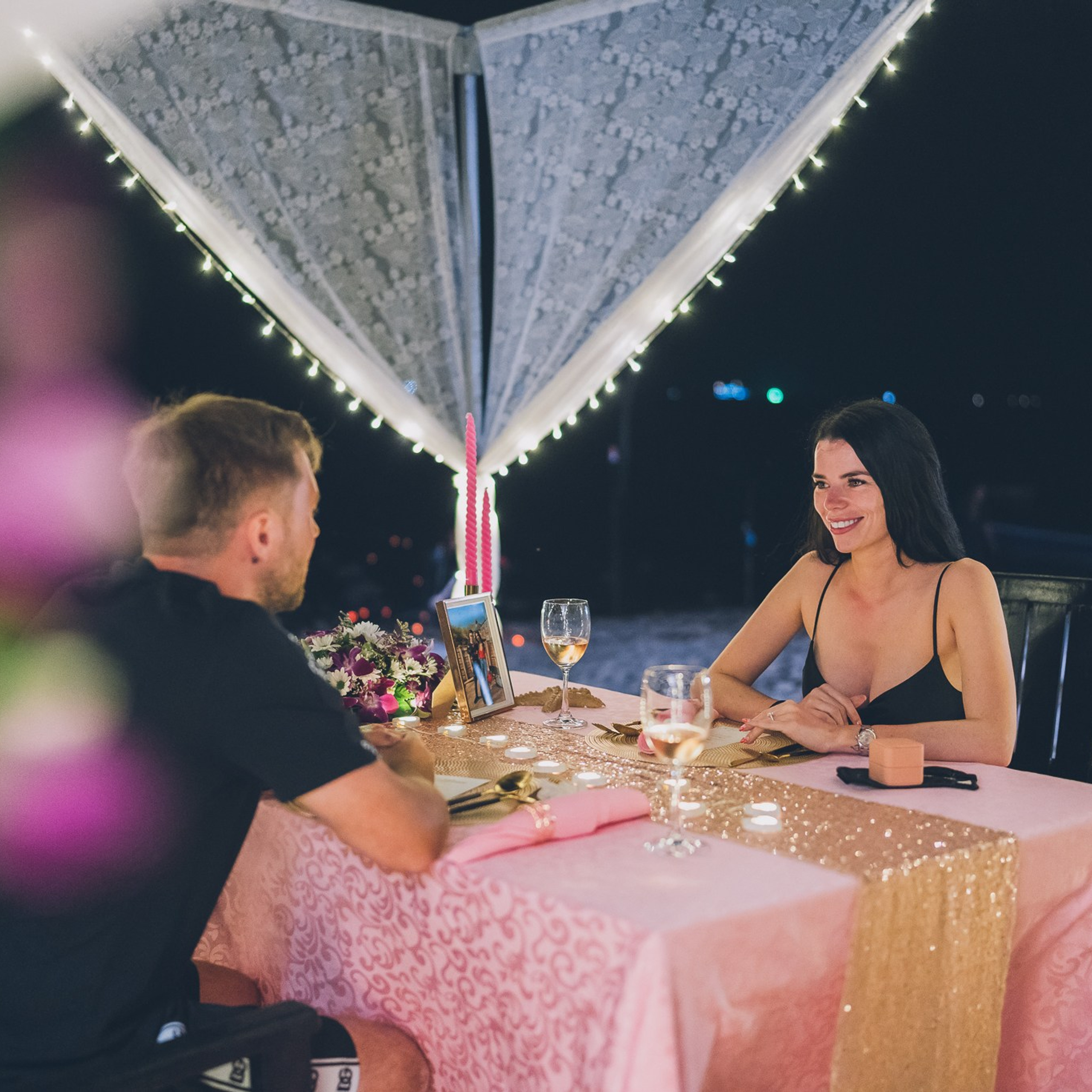 Romantic beach proposal setup in Koh Samui with candles and flower arch.