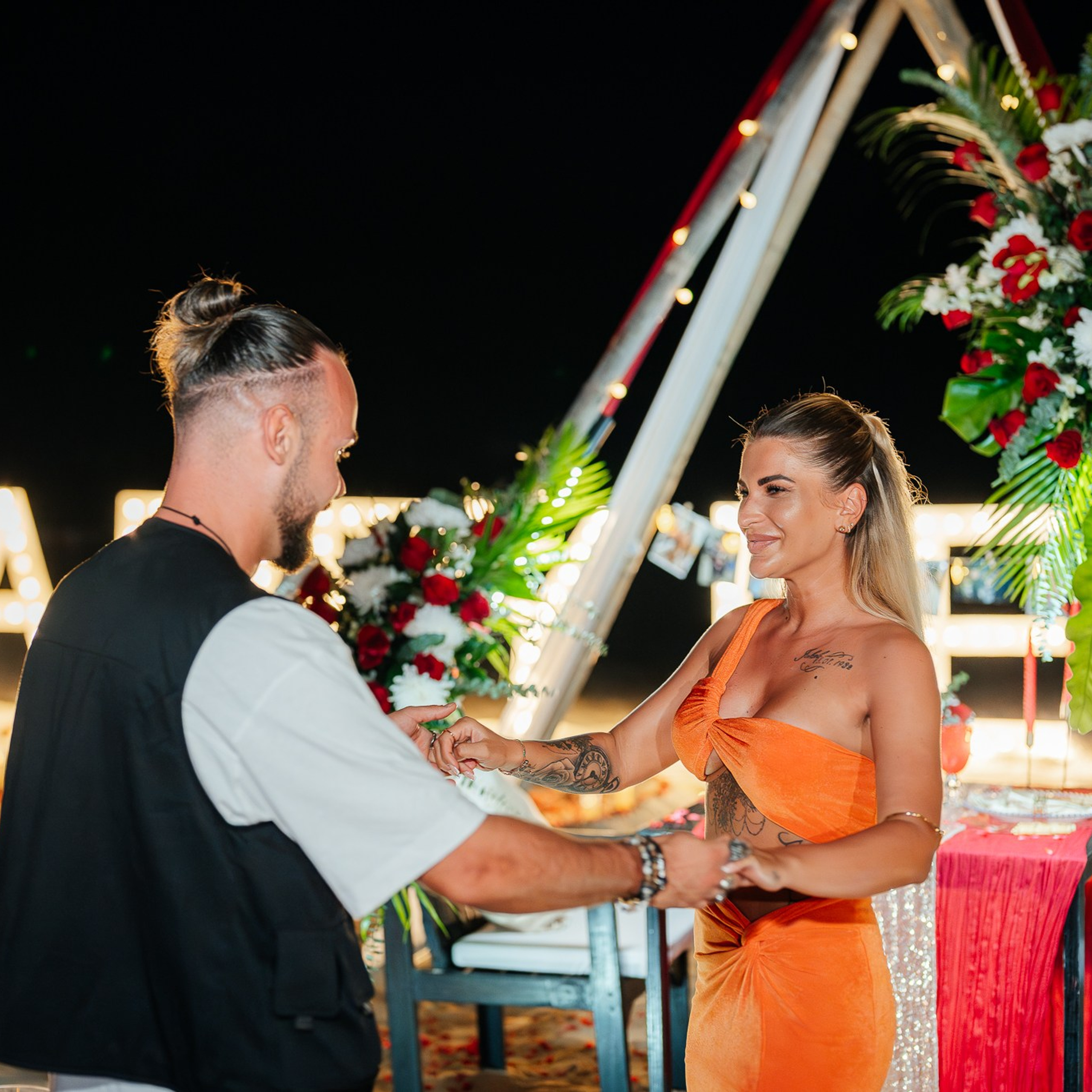 Romantic beach proposal setup in Koh Samui with candles and flower arch.