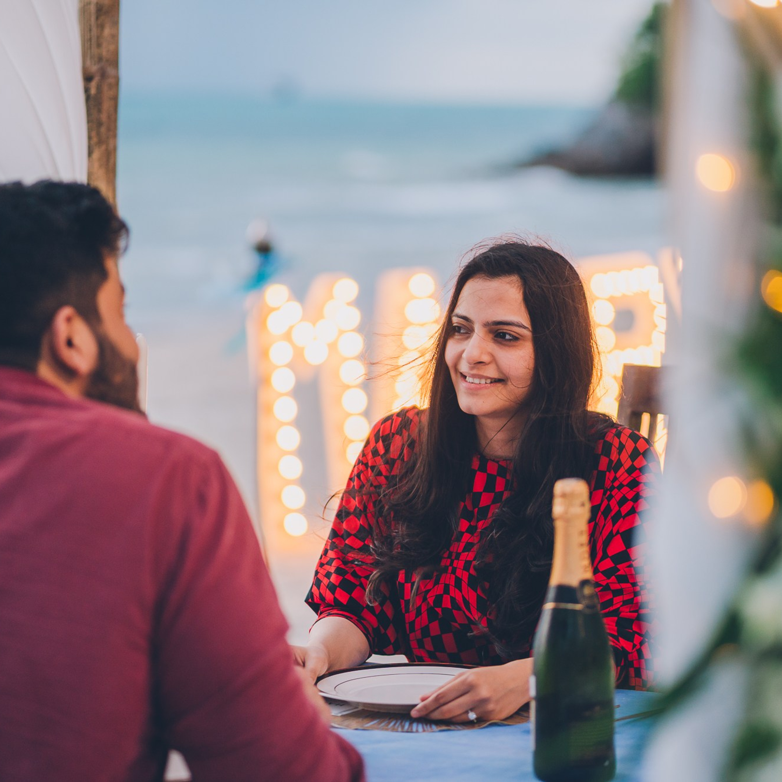 Romantic beach proposal setup in Koh Samui with candles and flower arch.