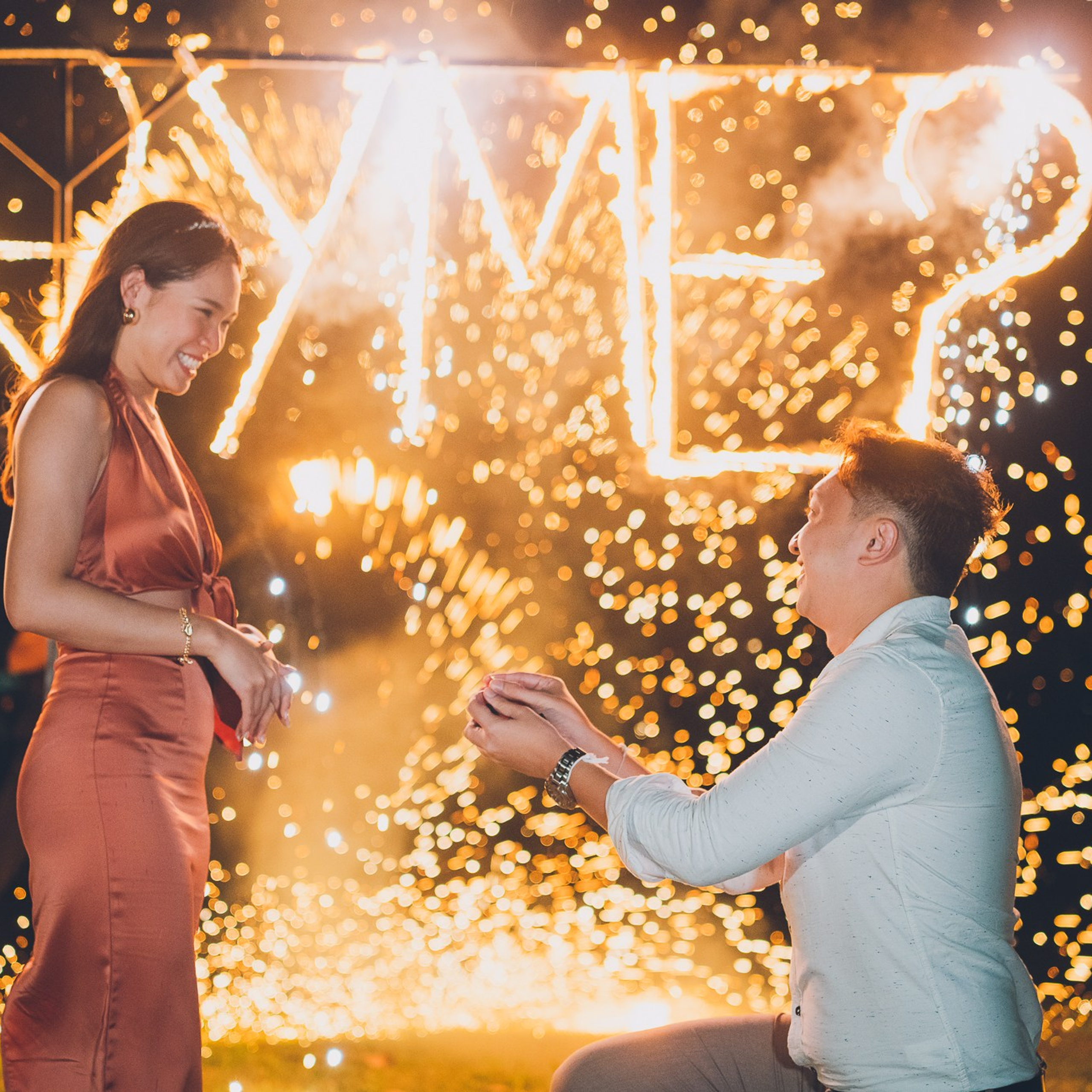 Romantic beach proposal setup in Koh Samui with candles and flower arch.