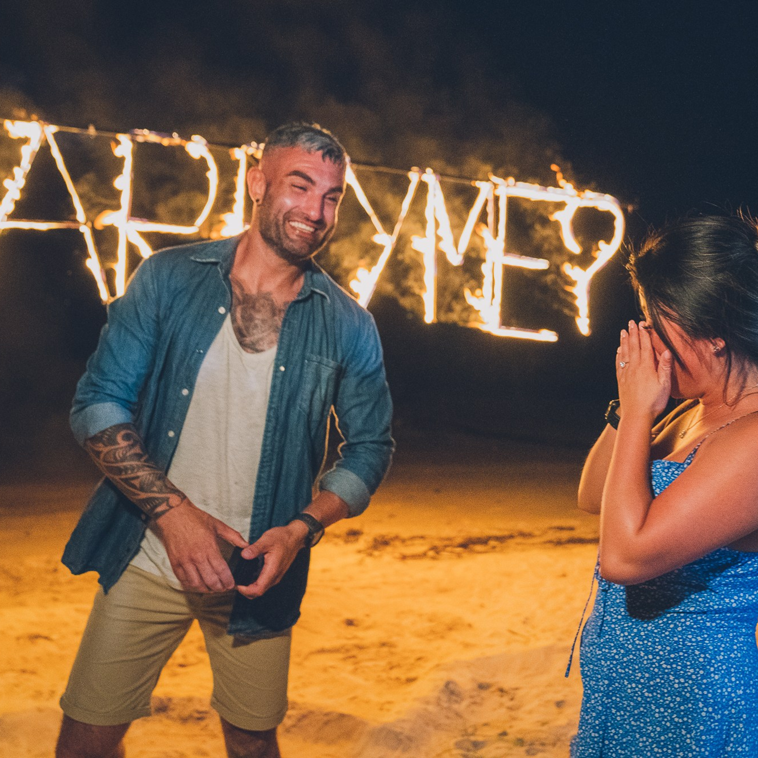 Romantic beach proposal setup in Koh Samui with candles and flower arch.
