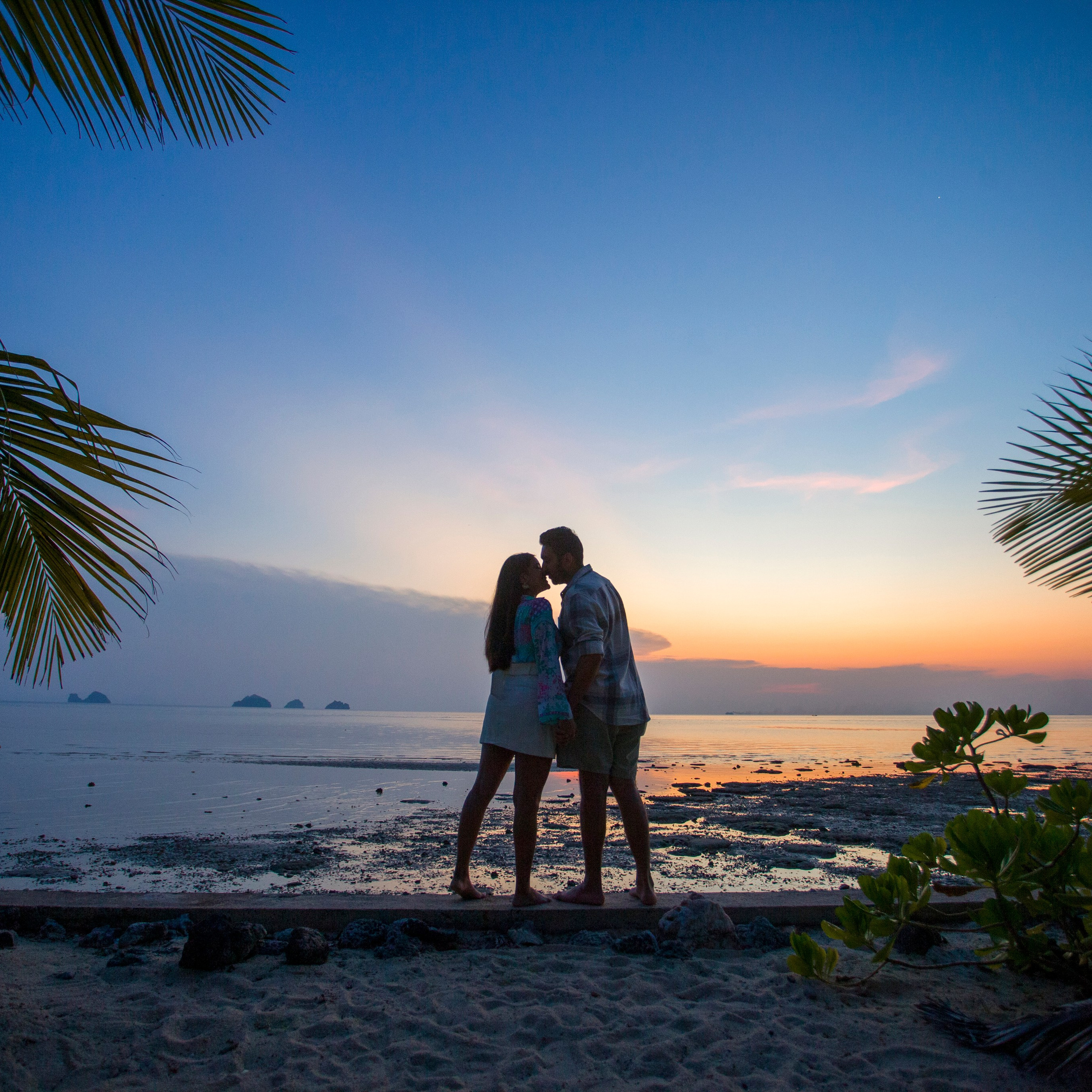 Romantic beach proposal setup in Koh Samui with candles and flower arch.