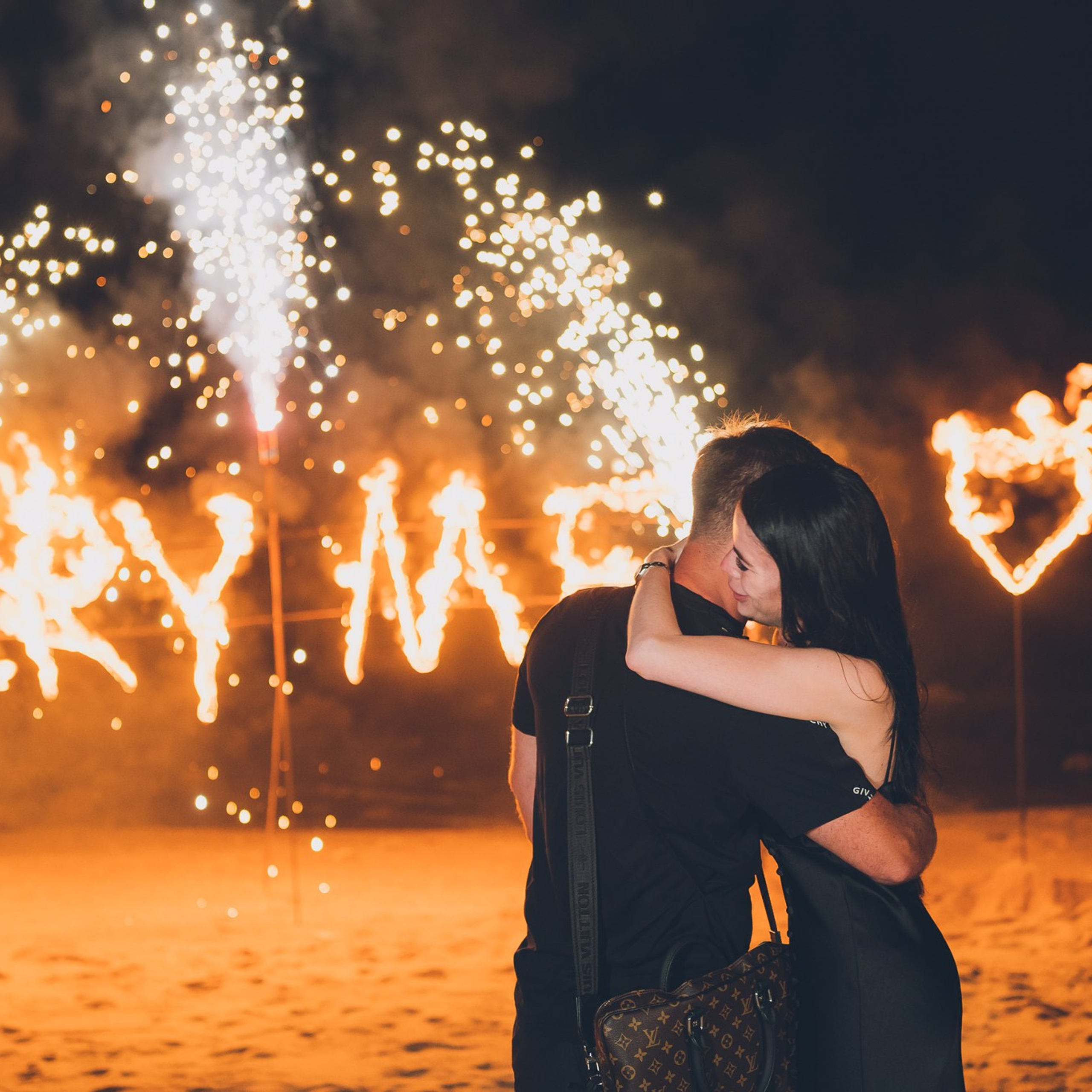 Romantic beach proposal setup in Koh Samui with candles and flower arch.