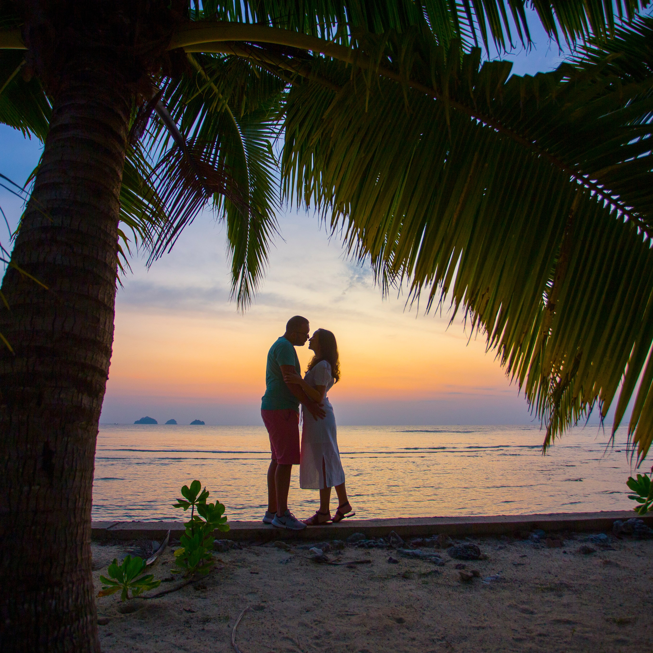 Romantic beach proposal setup in Koh Samui with candles and flower arch.