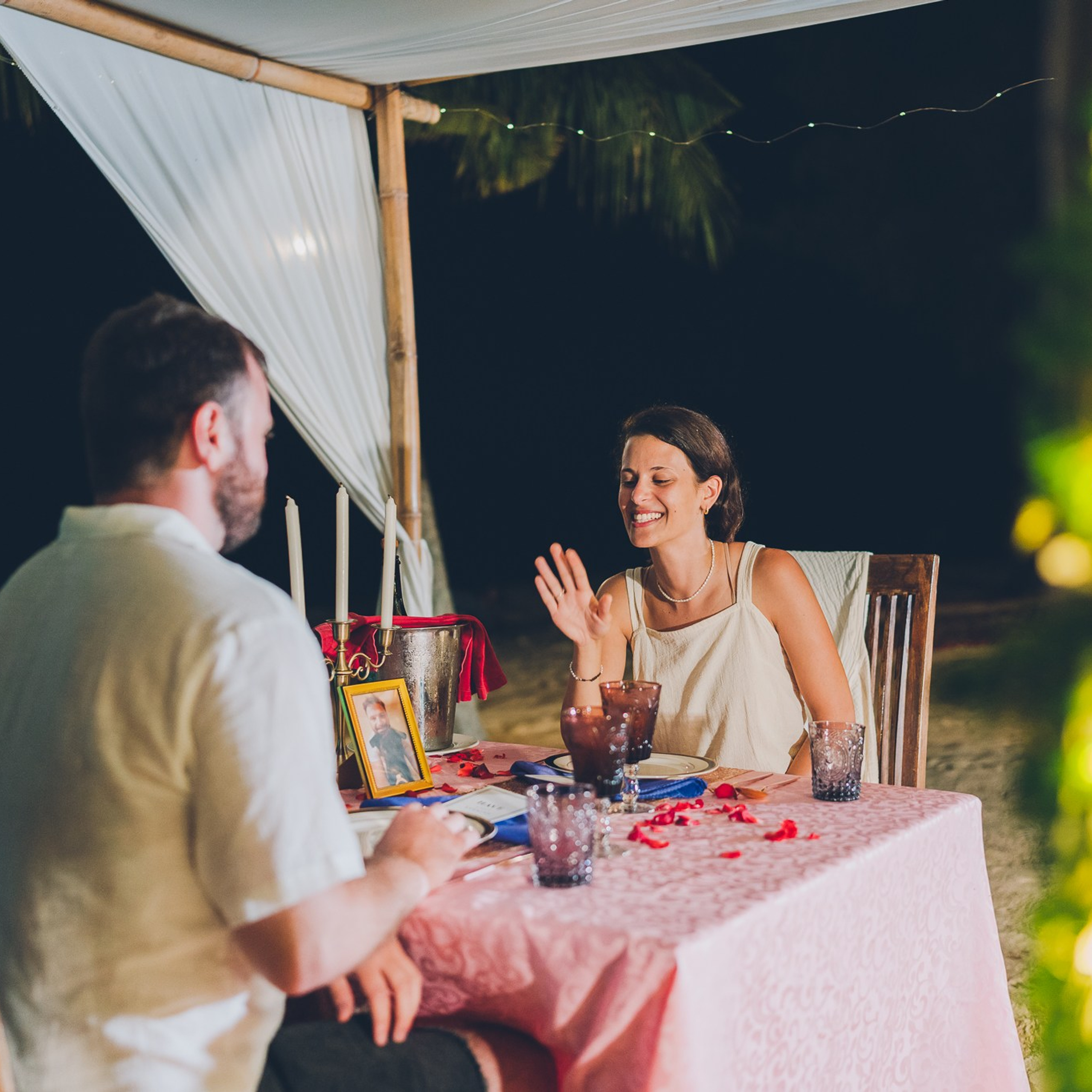Romantic beach proposal setup in Koh Samui with candles and flower arch.