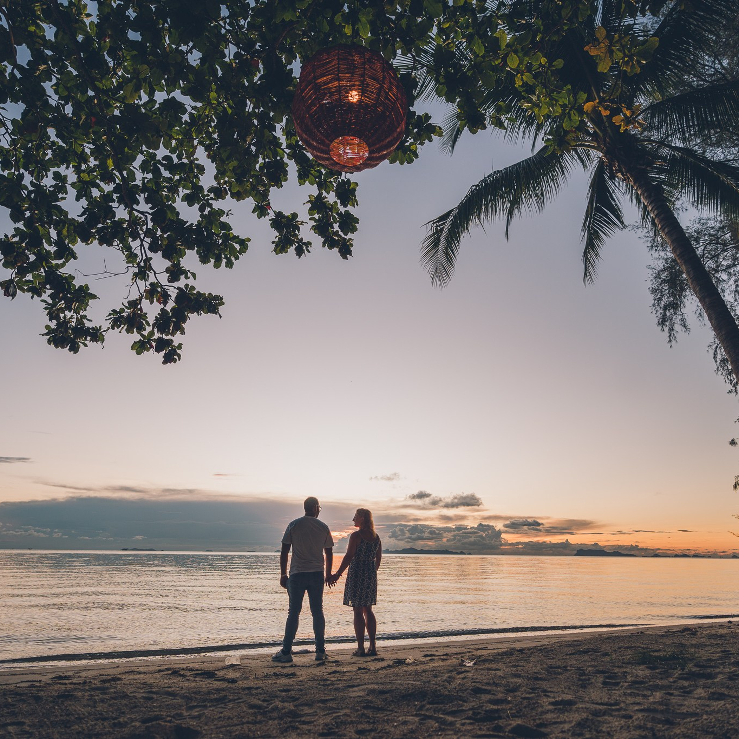 Romantic beach proposal setup in Koh Samui with candles and flower arch.