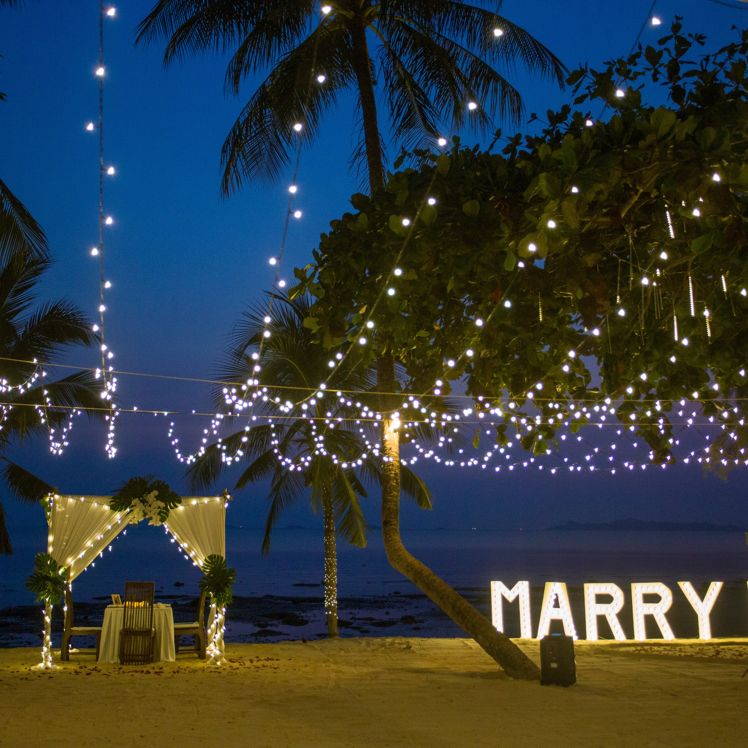Luxury beach proposal in Koh Samui, Thailand. Private sunset setup with candles, flowers, and ocean view for an unforgettable engagement experience.