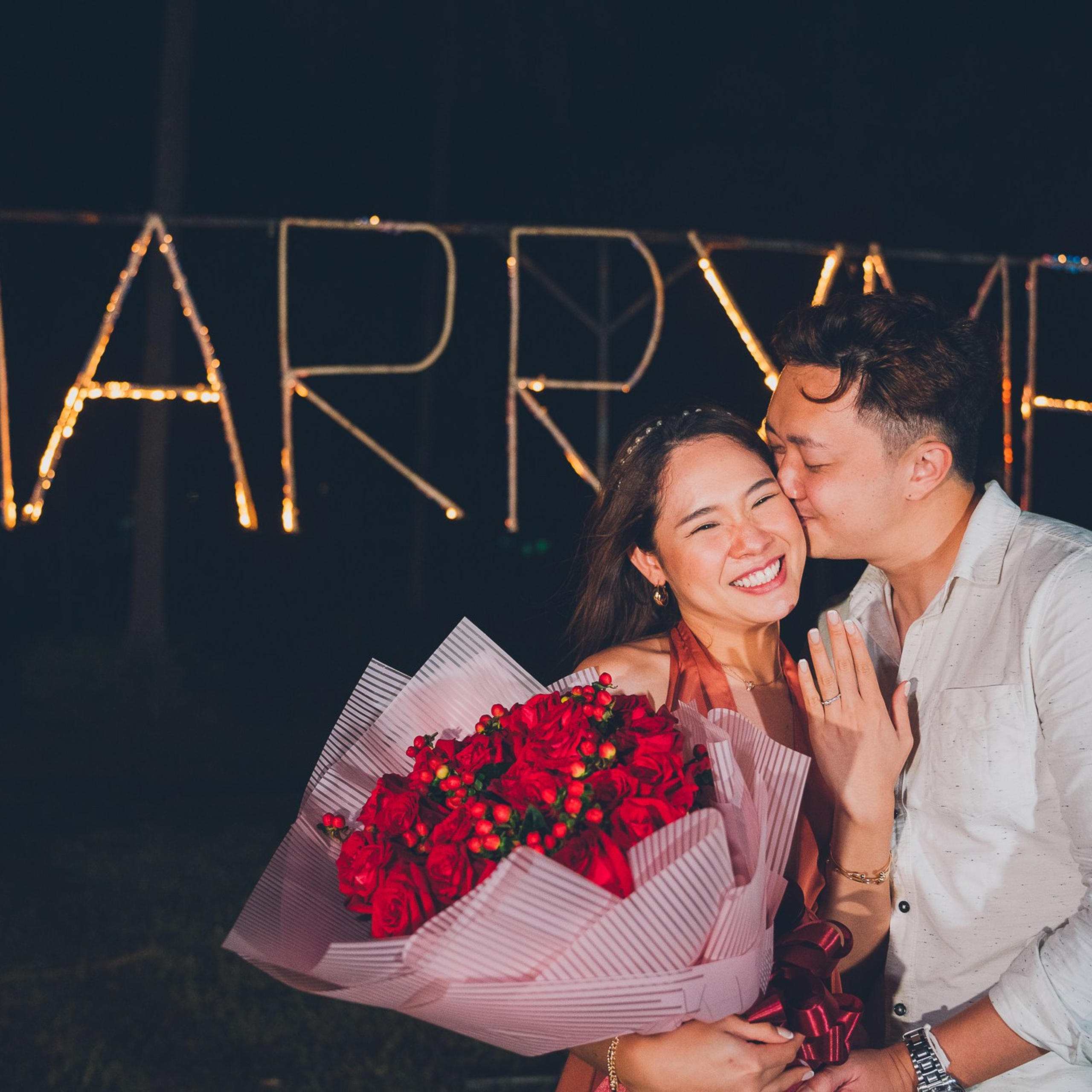 Romantic beach proposal setup in Koh Samui with candles and flower arch.