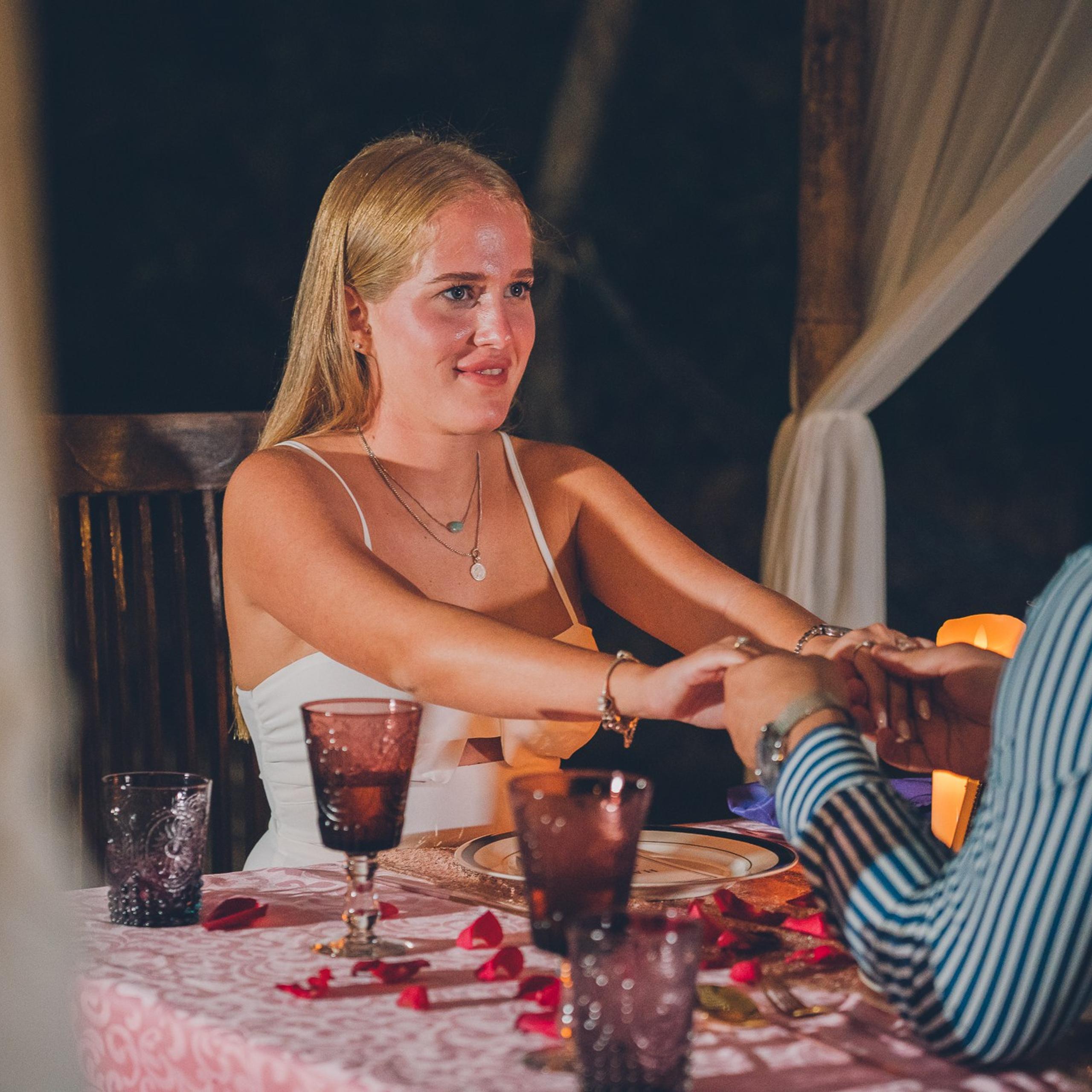 Romantic beach proposal setup in Koh Samui with candles and flower arch.