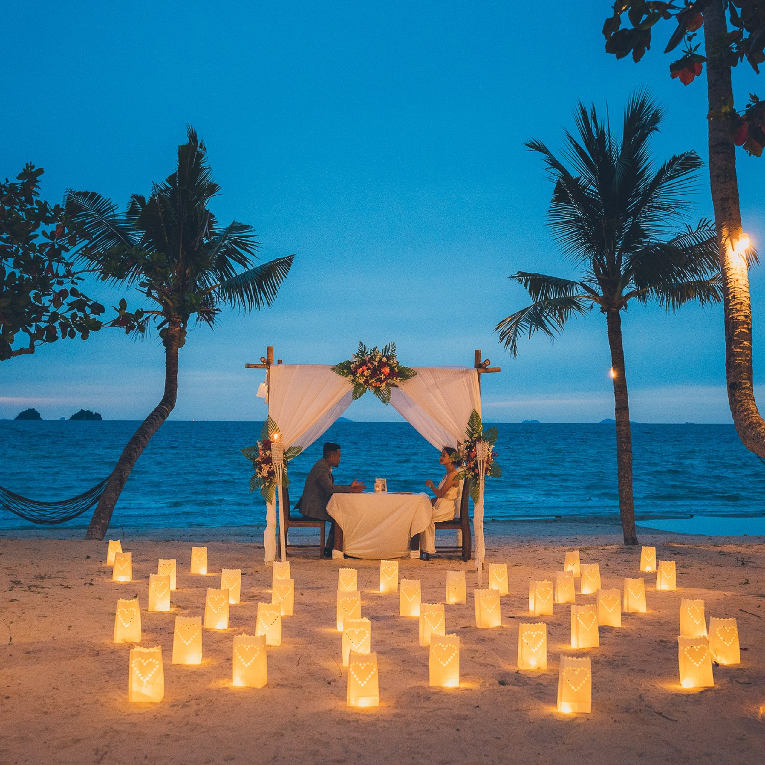 Luxury beach proposal in Koh Samui, Thailand. Private sunset setup with candles, flowers, and ocean view for an unforgettable engagement experience.