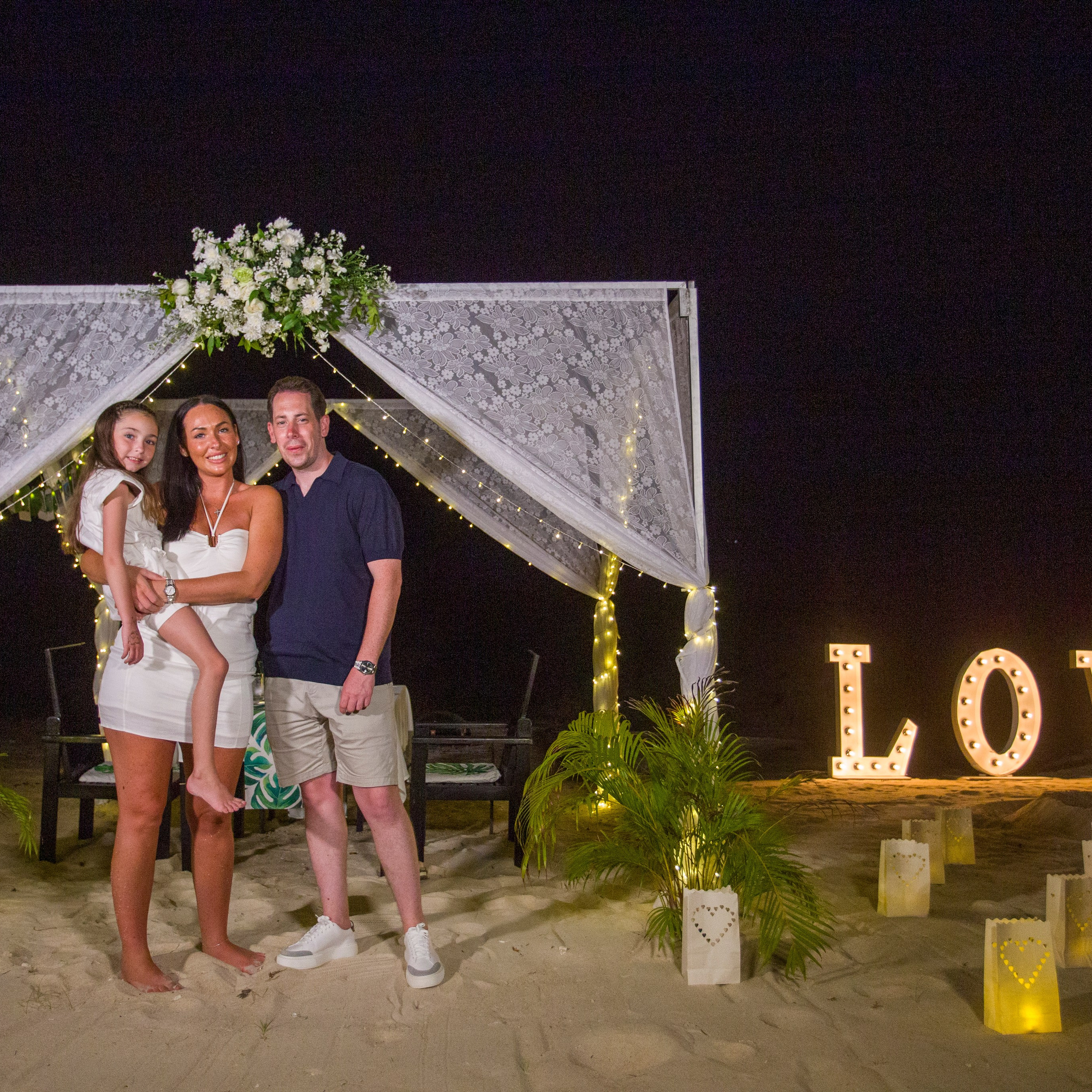 Romantic beach proposal setup in Koh Samui with candles and flower arch.