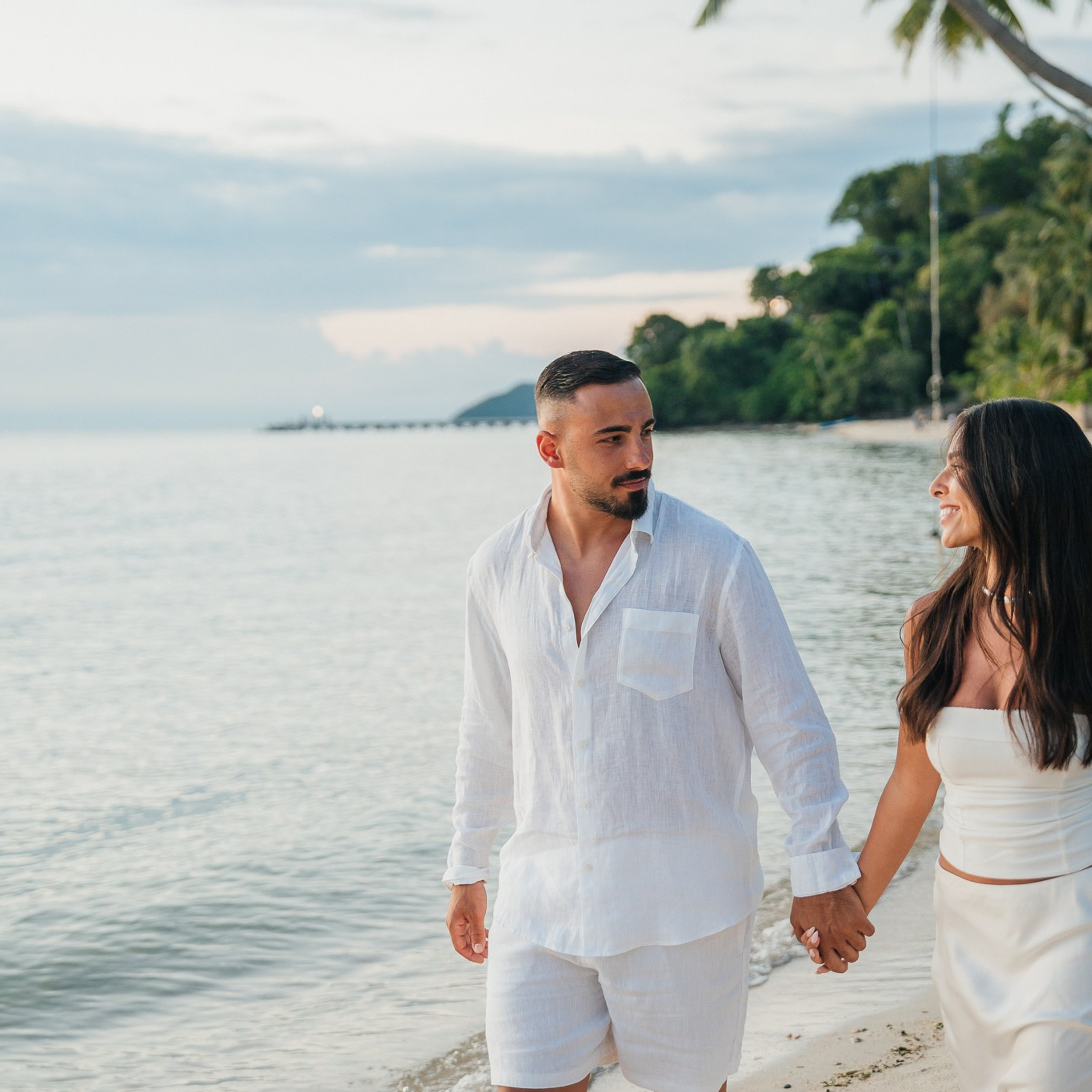 Romantic beach proposal setup in Koh Samui with candles and flower arch.