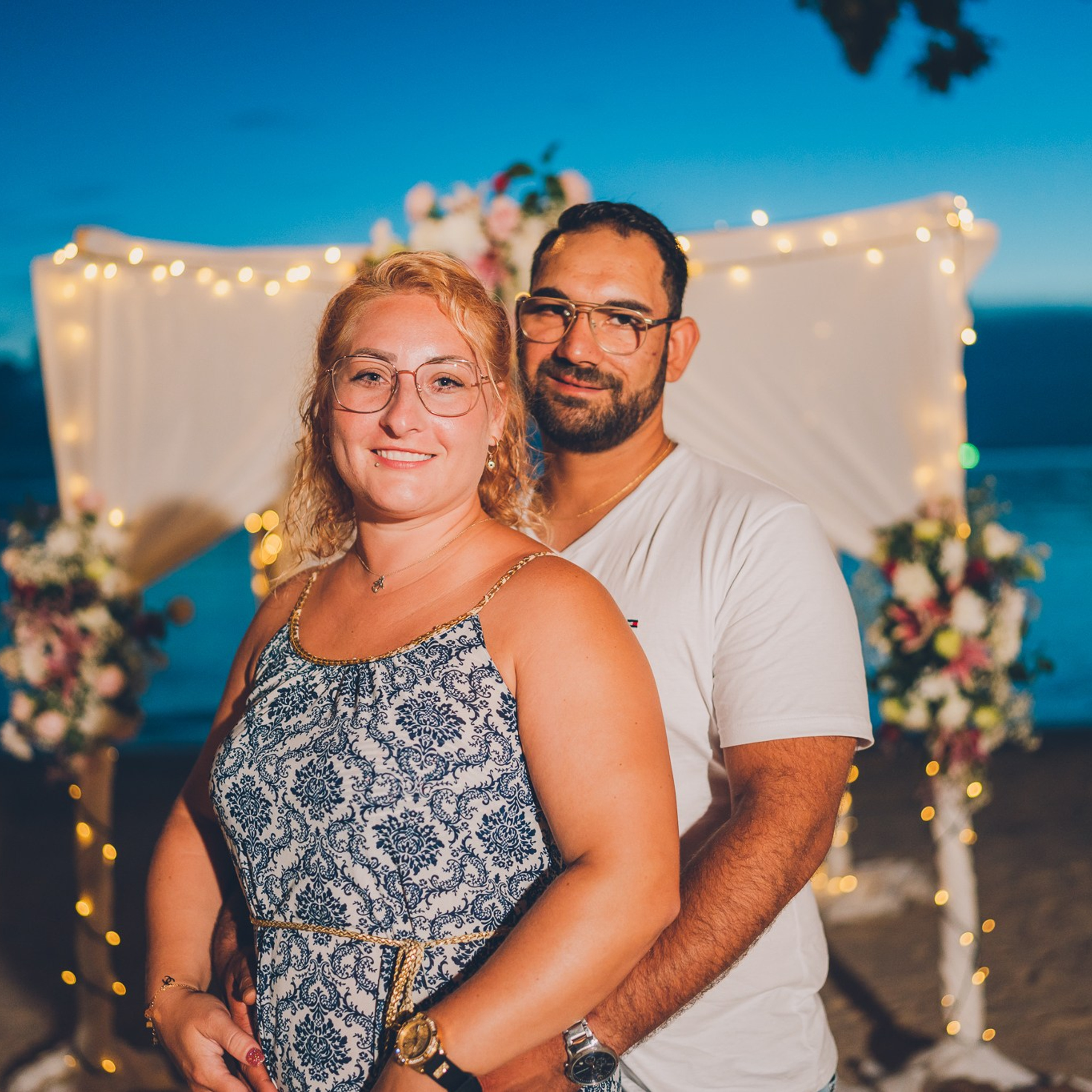 Romantic beach proposal setup in Koh Samui with candles and flower arch.