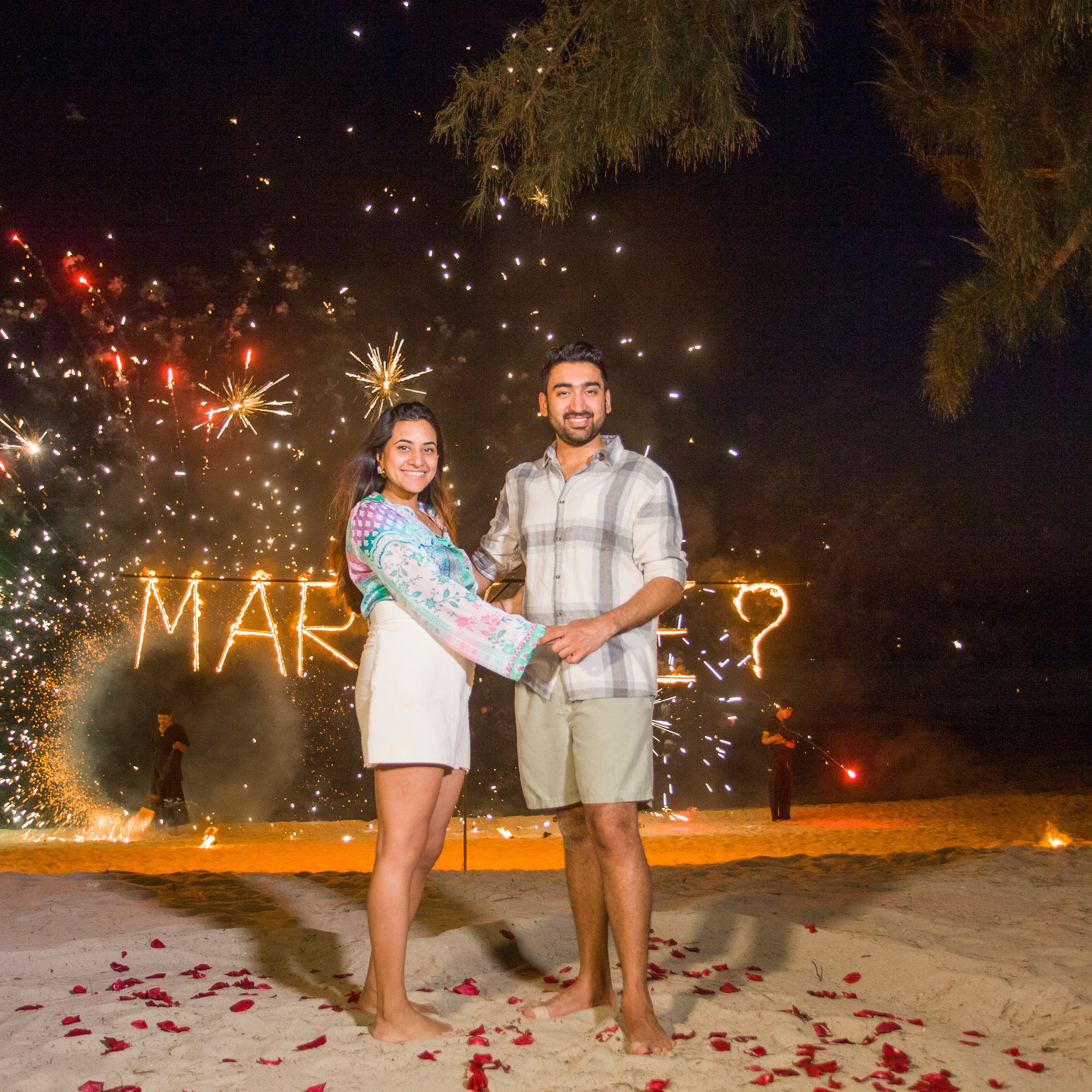 Romantic beach proposal setup in Koh Samui with candles and flower arch.